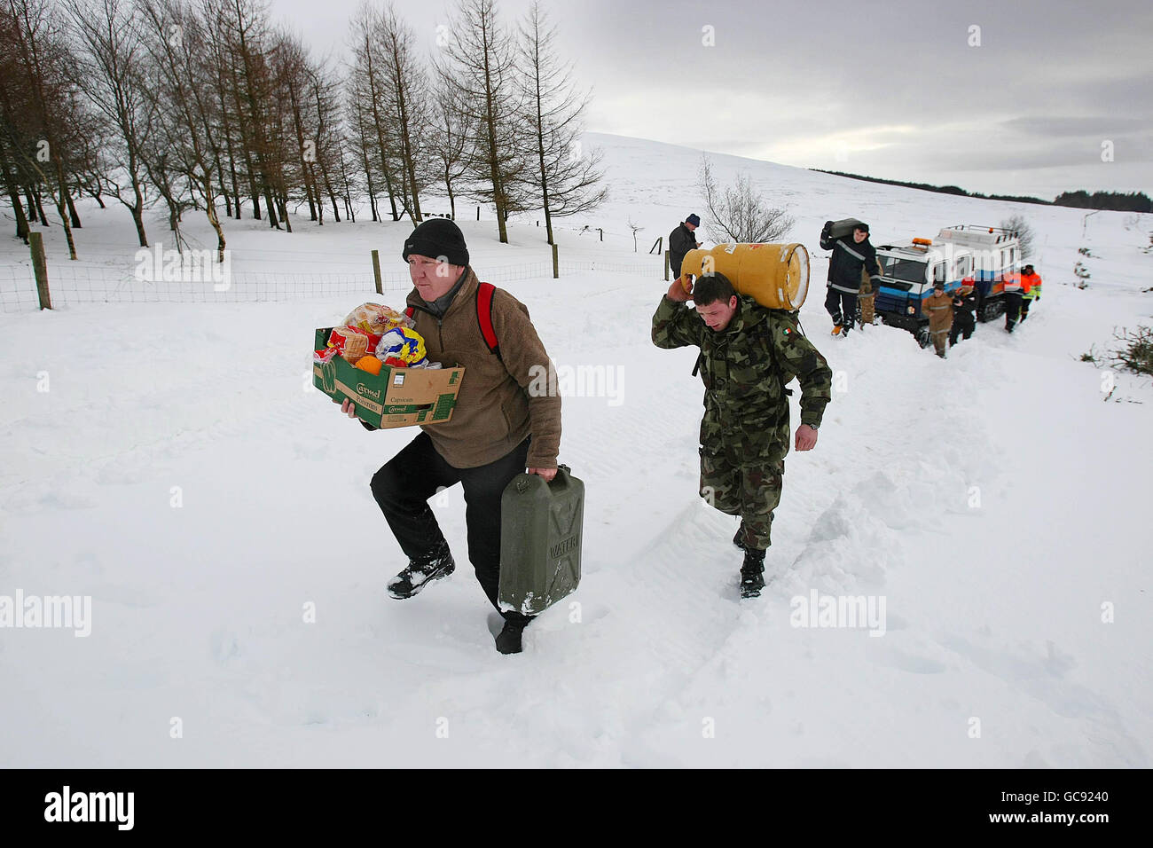 Le Cpl Sean O'Keefe et le cavalier Darren Beatty des Forces de défense ont pris des dispositions au camp militaire de Kilbride avec l'aide des membres de la Défense civile de Dublin après que l'ancien véhicule à chenilles Hagglunds de l'armée suédoise n'a pas pu terminer les dernières centaines de mètres en raison de déneigement jusqu'à 6 pieds de profondeur Dans des endroits dans les montagnes de Wicklow. Banque D'Images