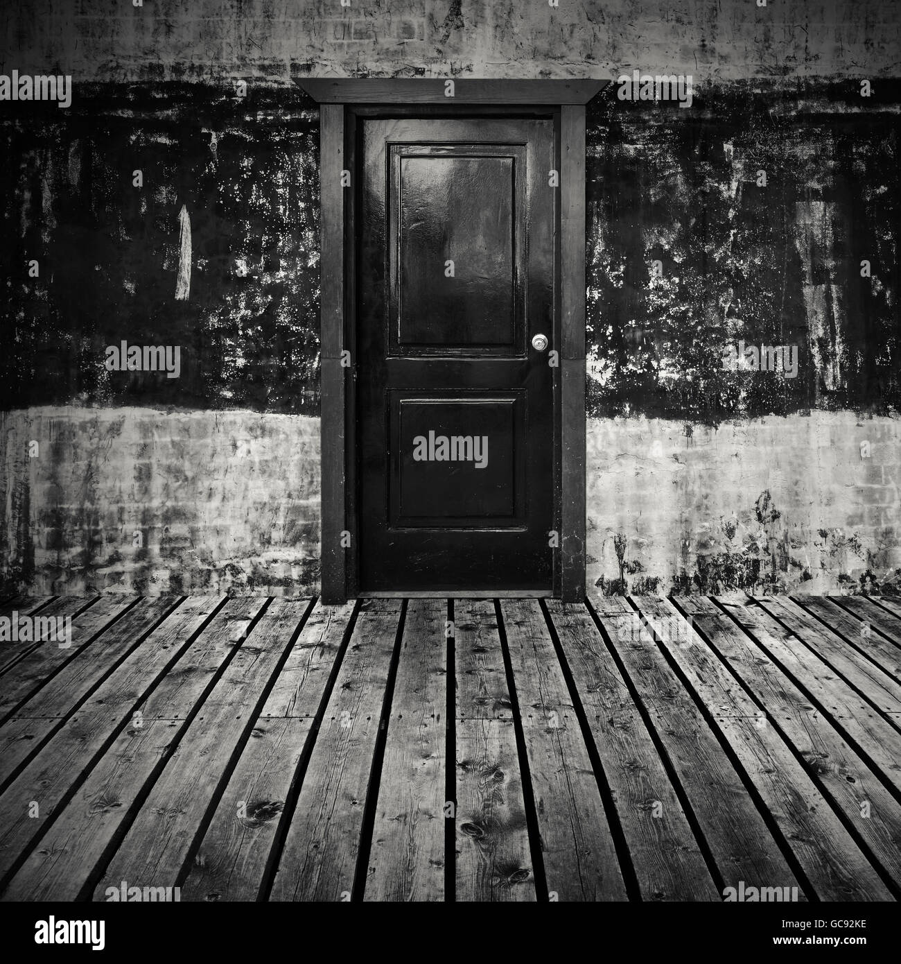 Résumé Contexte L'intérieur d'une chambre noire vide avec plancher en bois gris et noir porte au mur de béton Banque D'Images
