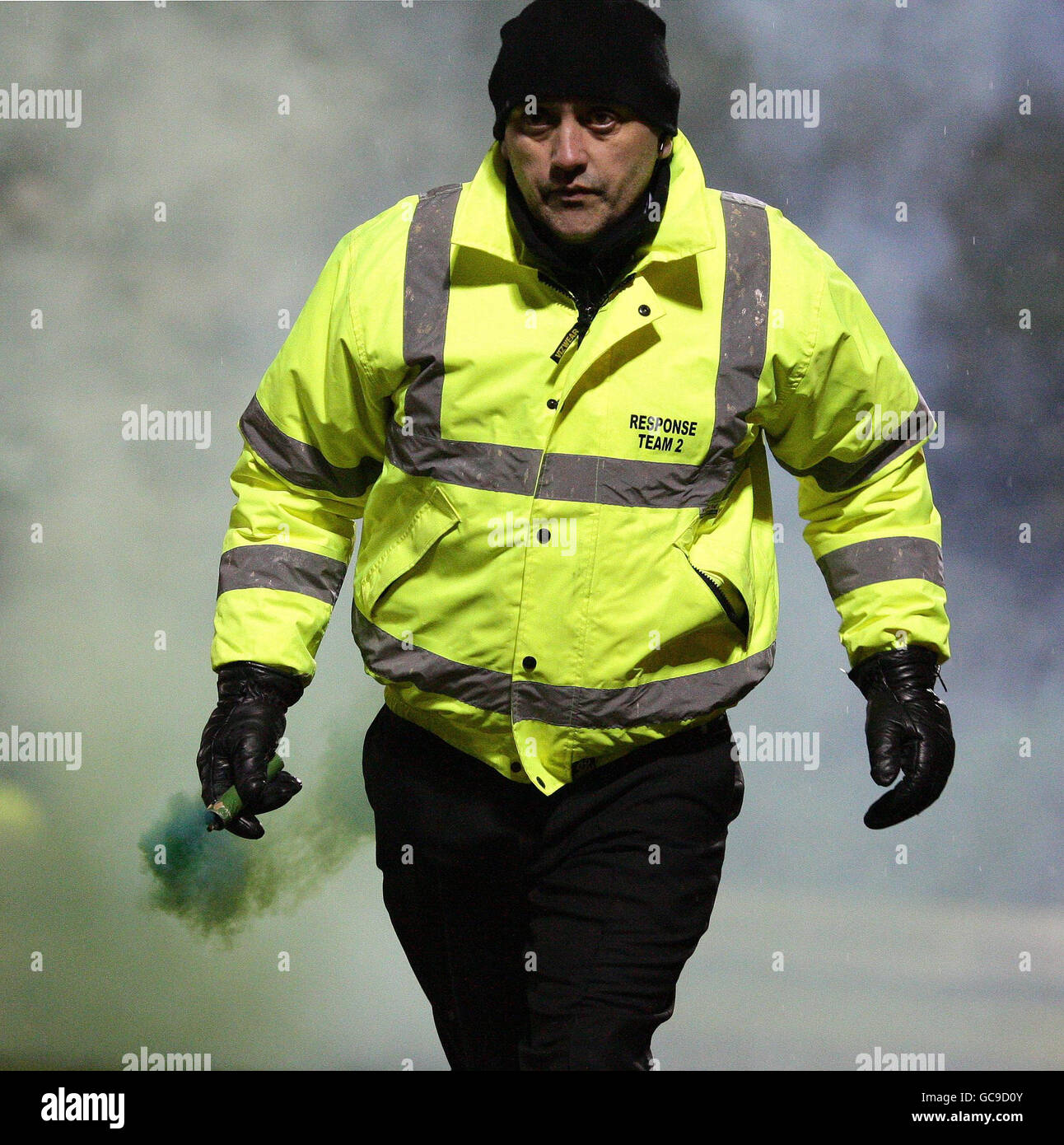 Un Steward arbore une poussée de vert sur le terrain lors du match de la Coca-Cola football League Two à Gigg Lane, Bury. Banque D'Images