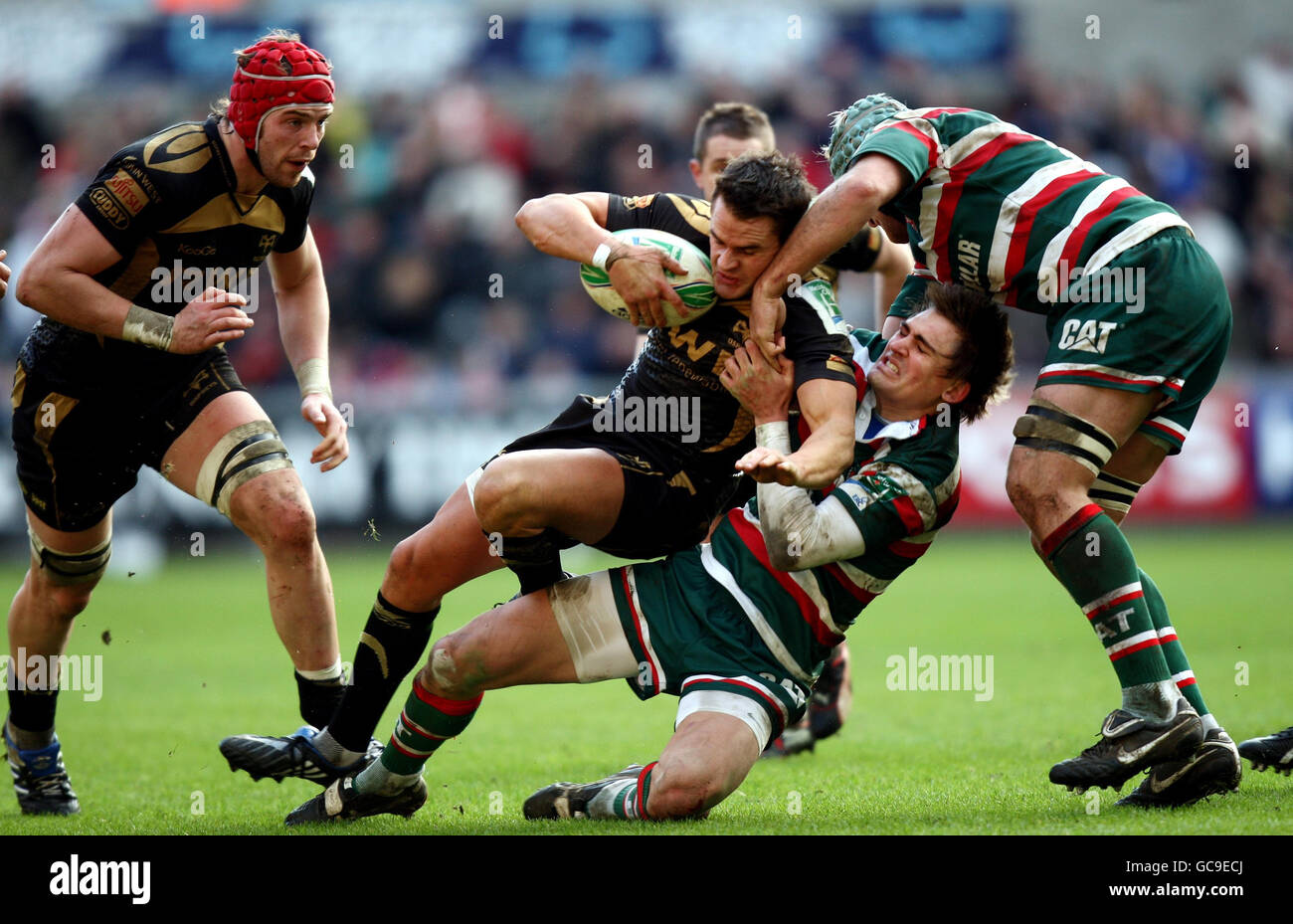 Ospreys Lee Byrne est attaqué par Toby Flood de Leicester lors du match de la coupe Heineken au Liberty Stadium, Swansea. Banque D'Images