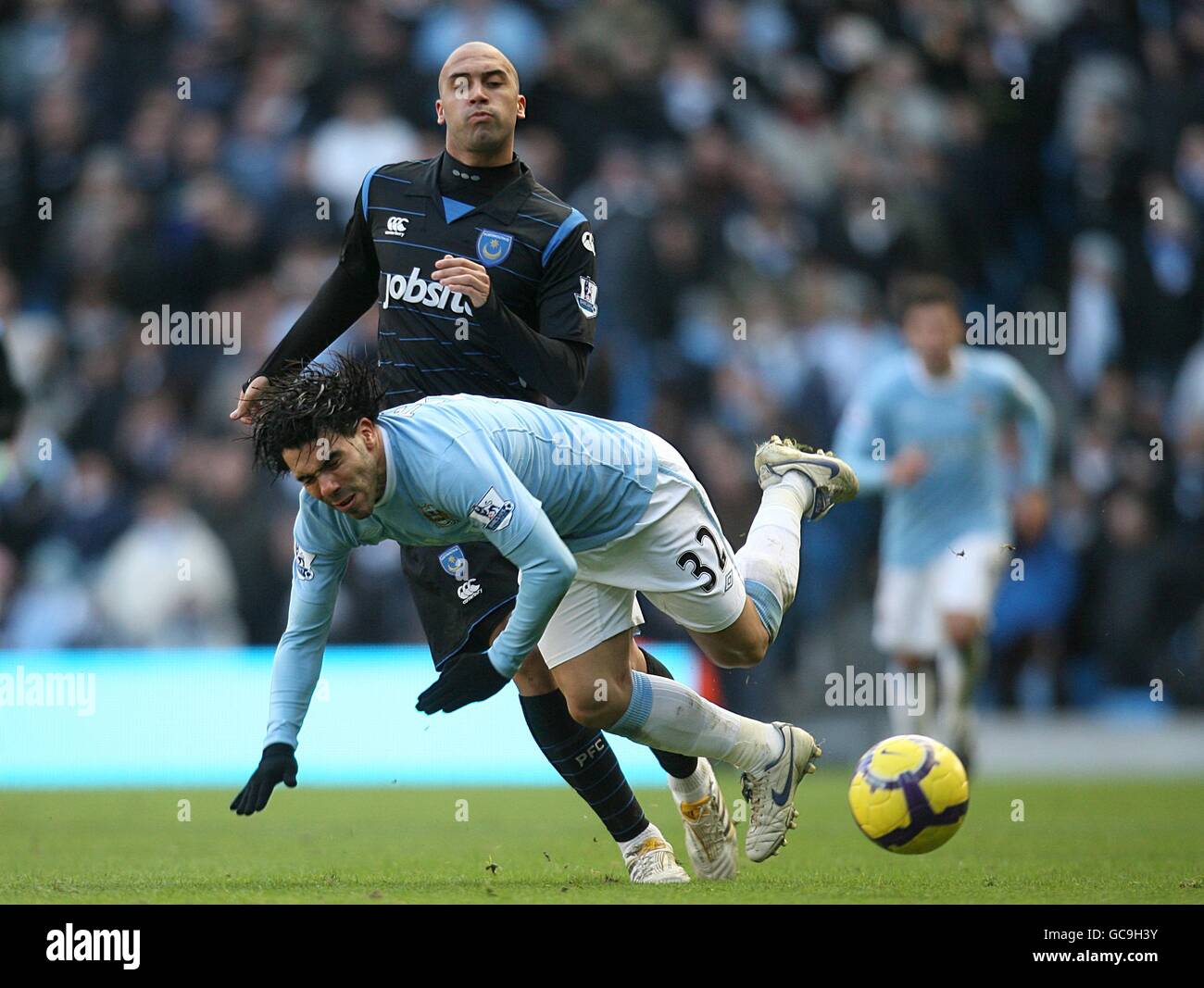 Football - Barclays Premier League - Manchester City v Portsmouth - City of Manchester Stadium.Carlos Tevez de Manchester City est descendu par Anthony Vanden Borre de Portsmouth Banque D'Images