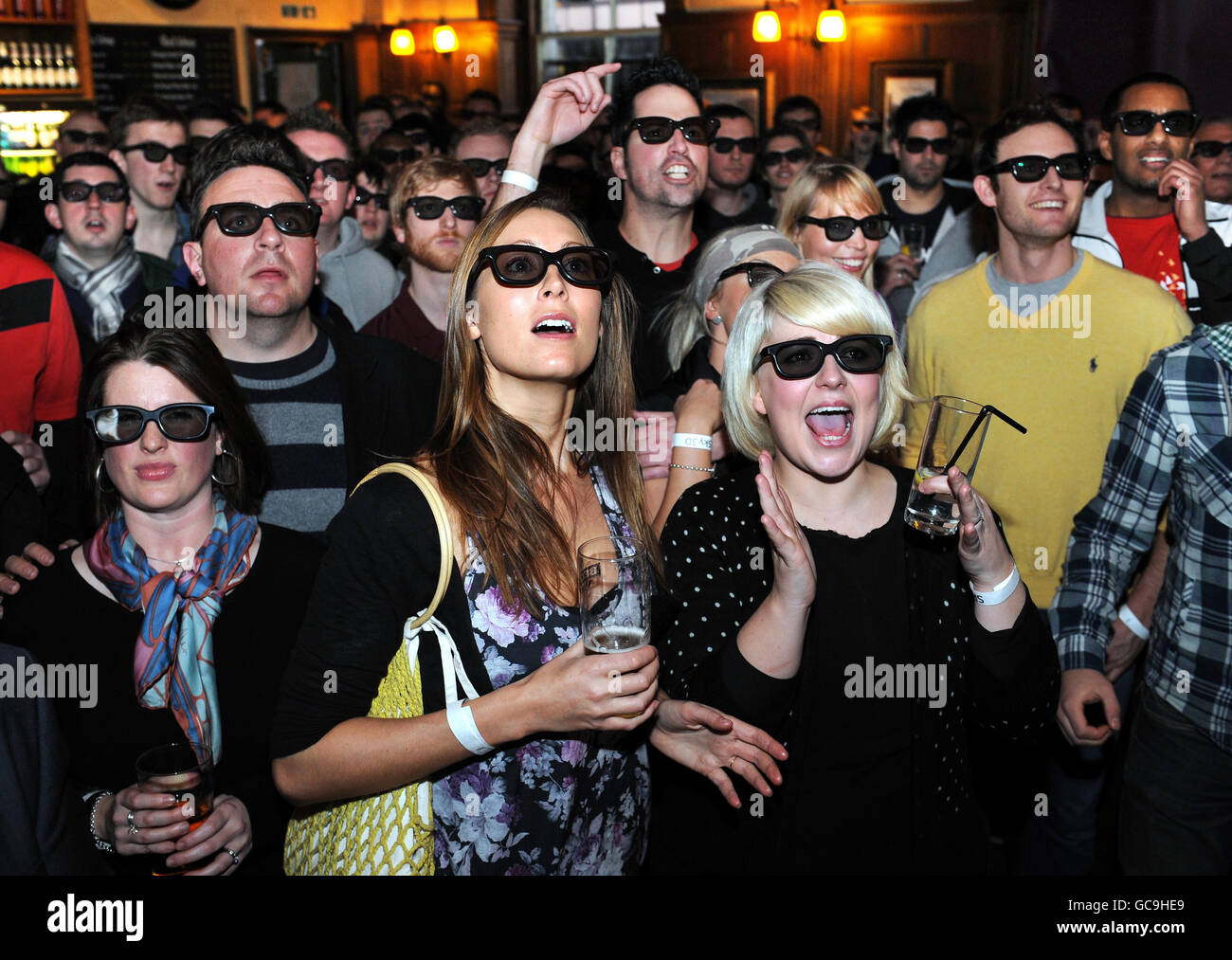 Les fans de football regardent le premier match de football en direct en 3D entre Arsenal et Manchester Utd dans la taverne ferroviaire de Londres. Banque D'Images