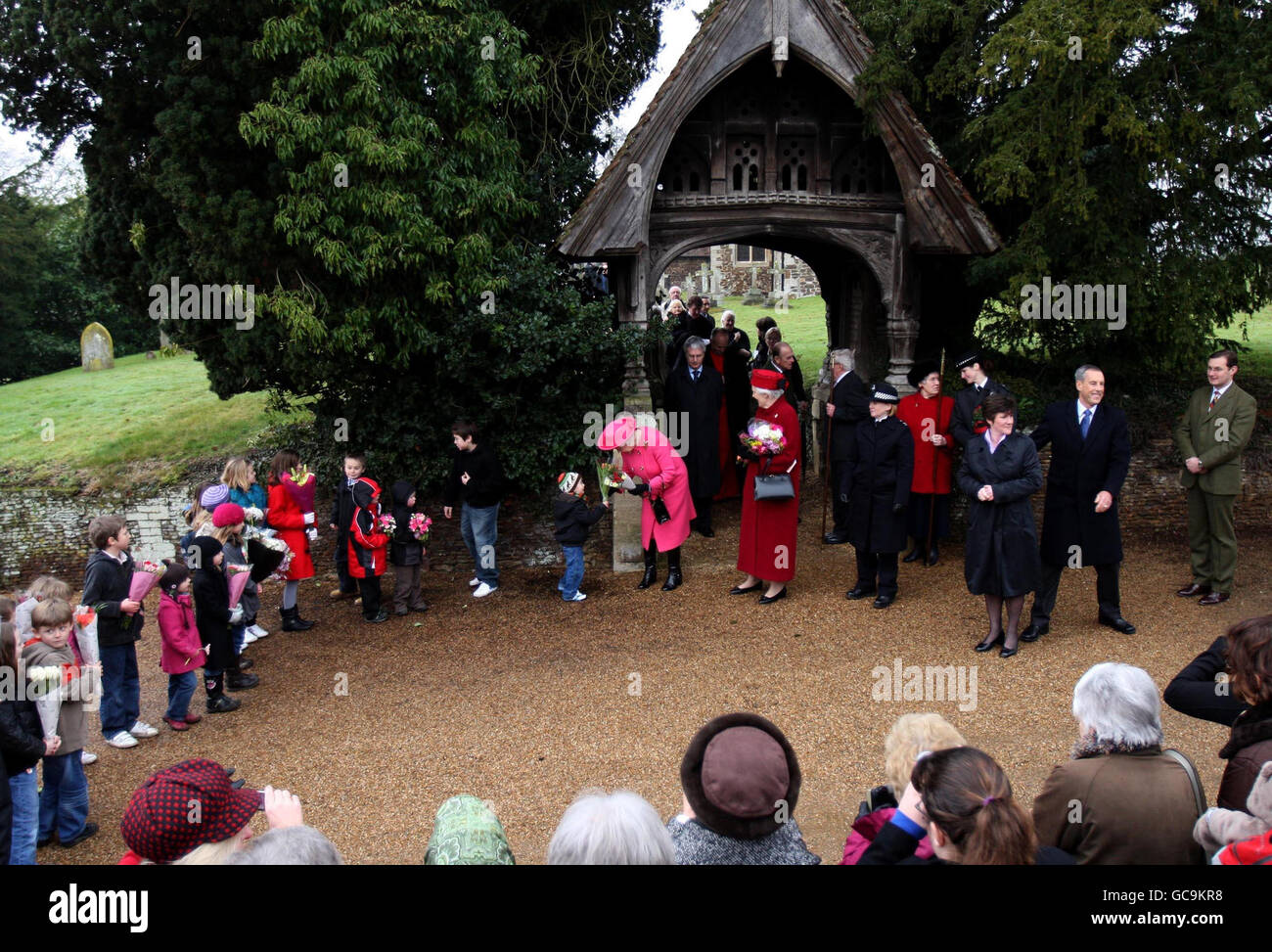 La reine Elizabeth II reçoit des fleurs d'enfants après avoir assisté au service du dimanche à l'église West Newton, près de Sandringham, Norfolk. Banque D'Images