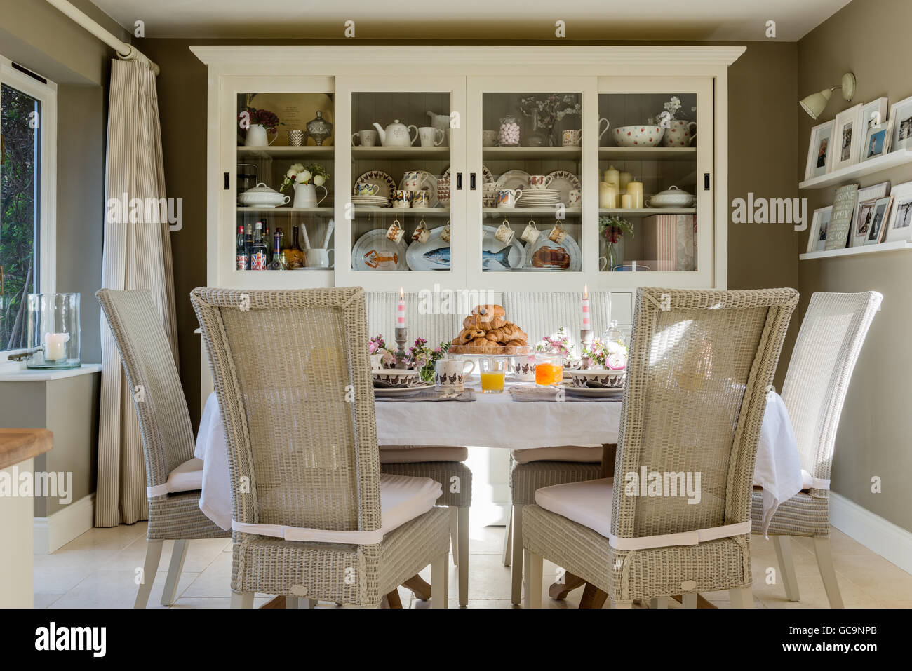 Fulham Lloyd Loom chaise de salle à manger autour de table les croissant.  Une grande commode blanche se trouve dans l'arrière-plan Photo Stock - Alamy