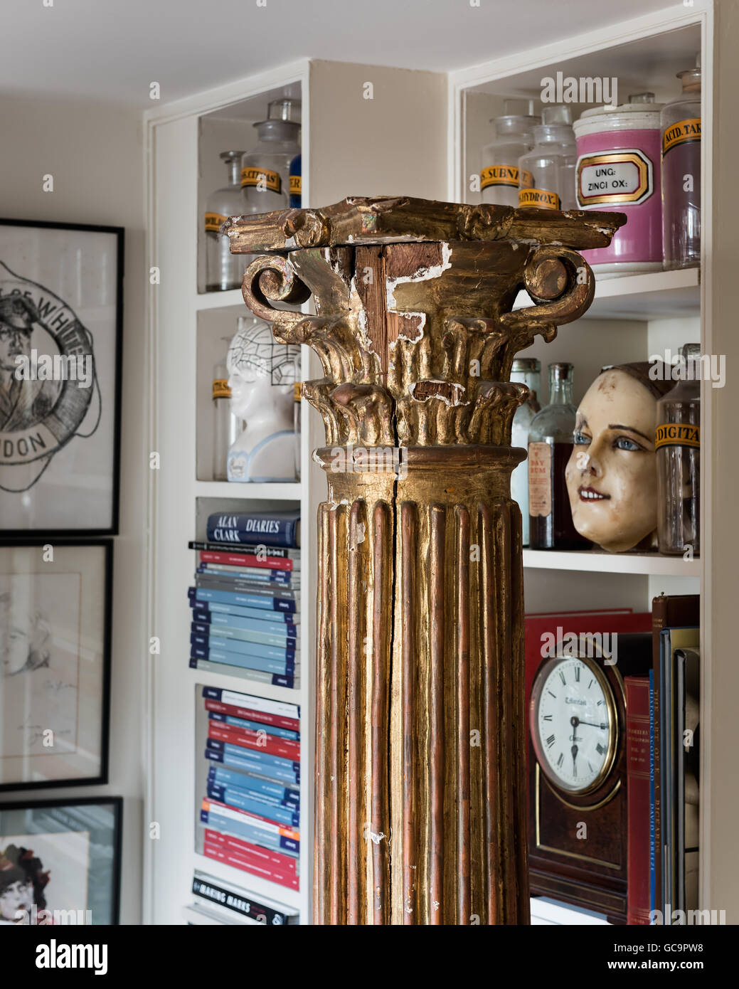 Pots d'apothicaire et de livres sur des étagères avec un pilier en appartement à Londres rempli de bibelots Banque D'Images
