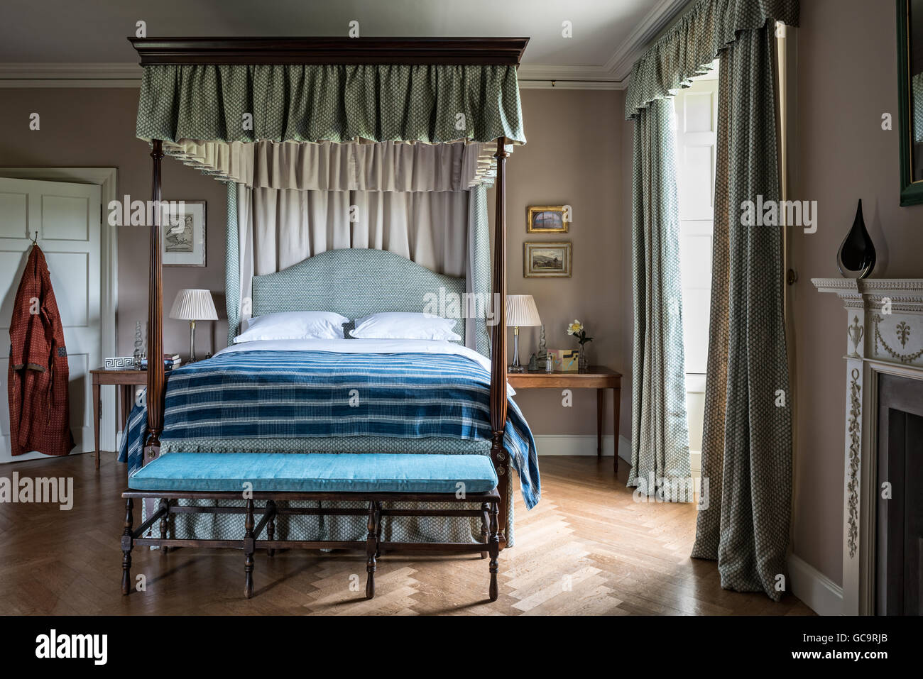 Lit à baldaquin dans la chambre à coucher avec parquet et mobilier banc avec coussin bleu. L'Afrique de l'Ouest est de indigo Banque D'Images