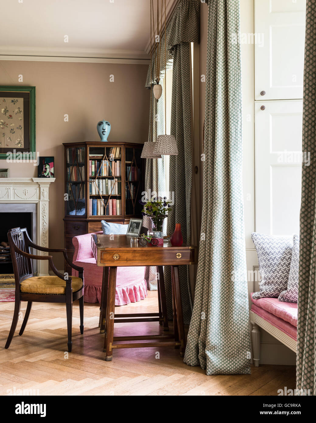 De vieux navires table dans une chambre avec cheminée et élégante pièce encadrée de chintz. papier peint Banque D'Images