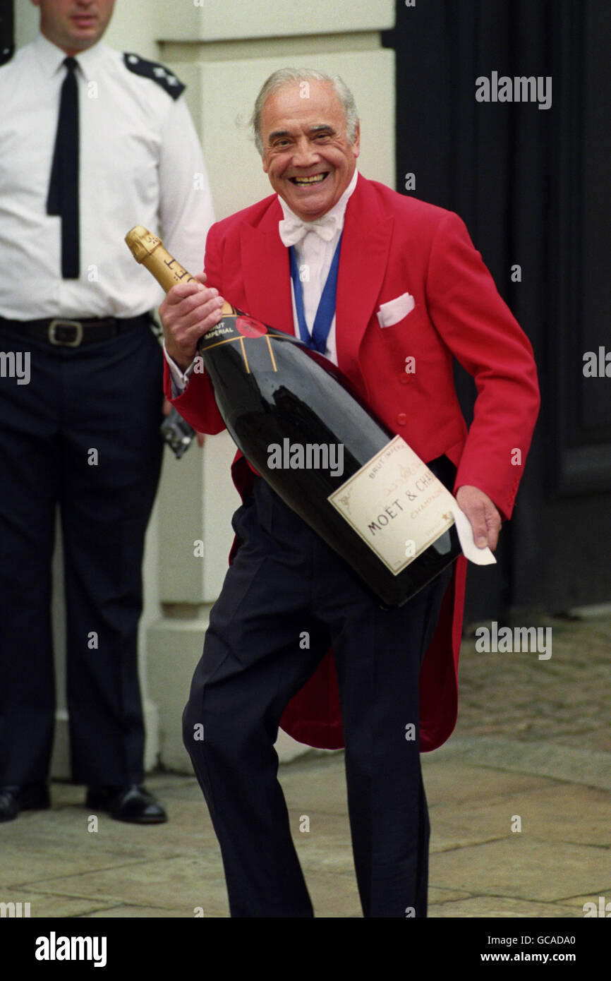 IVOR SPENCER PORTE UNE TRÈS GRANDE BOUTEILLE DE CHAMPAGNE EN PRÉPARATION POUR LES CÉLÉBRATIONS DU 94E ANNIVERSAIRE DE LA REINE MÈRE. Banque D'Images