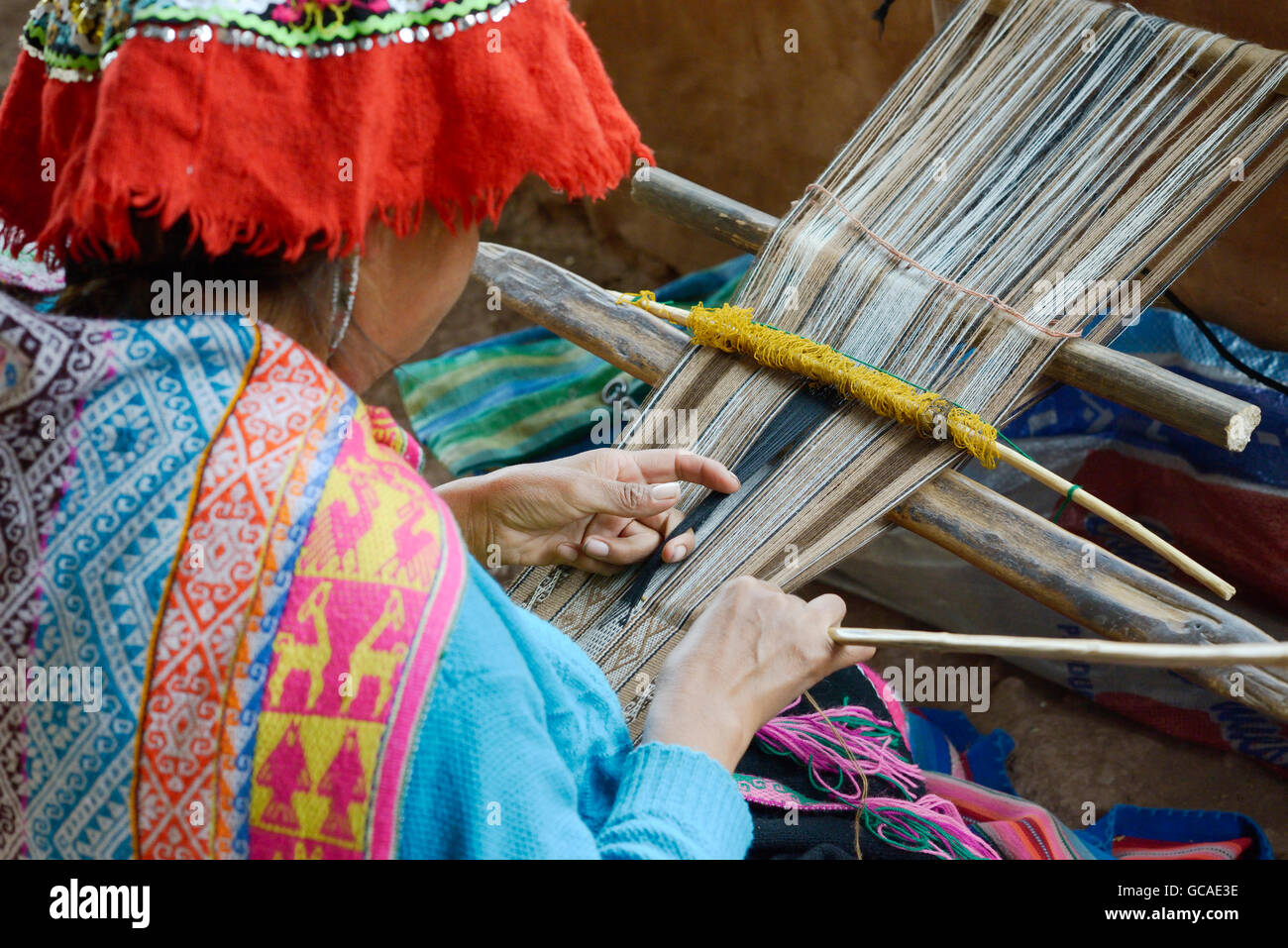Femme péruvienne en costume traditionnel tissu tissage sur un métier à tisser à la main dans les montagnes des Andes, Pérou Banque D'Images