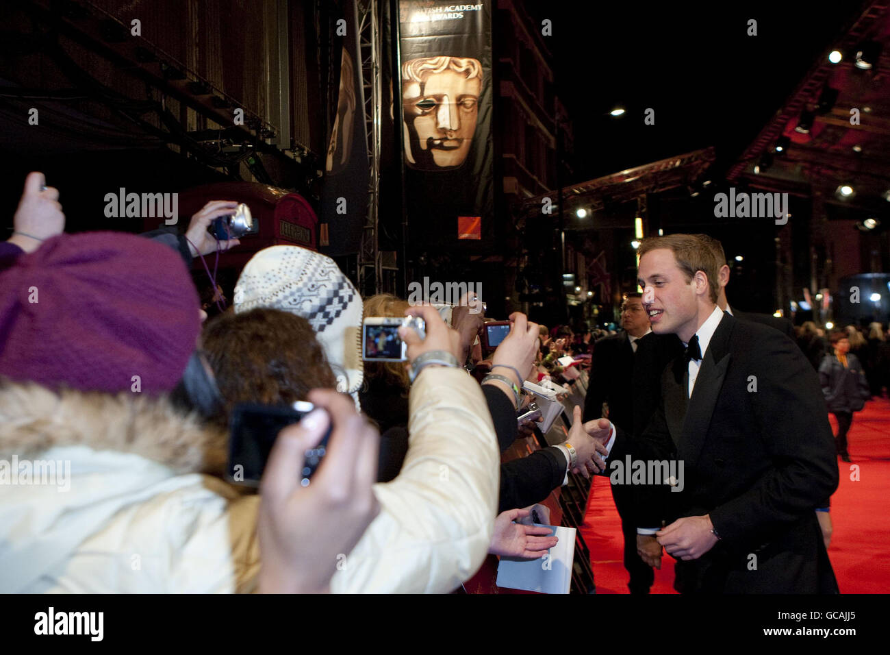 Le Prince William rencontre des fans lorsqu'il arrive aux Orange British Academy film Awards, à l'Opéra Royal de Londres. Banque D'Images