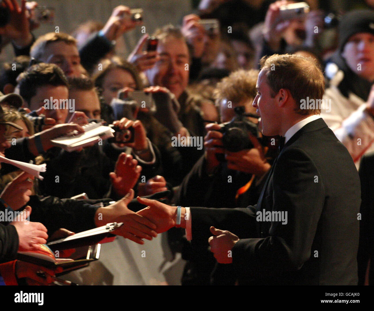Le Prince William accueille ses fans lorsqu'il arrive aux Orange British Academy film Awards, à l'Opéra Royal de Londres. Banque D'Images