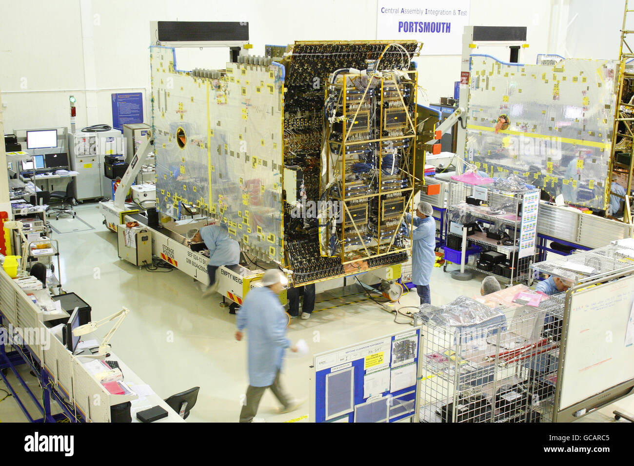 Des ingénieurs travaillent sur un satellite de la bande KA dans la salle blanche de Neptune à Astrium à Portsmouth. Il sera achevé d'ici le week-end et contribuera à fournir une large bande haute vitesse lorsqu'il sera mis en orbite en 2011. Astrium fait partie d'EADS qui possède également Airbus et Eurocopter. Banque D'Images