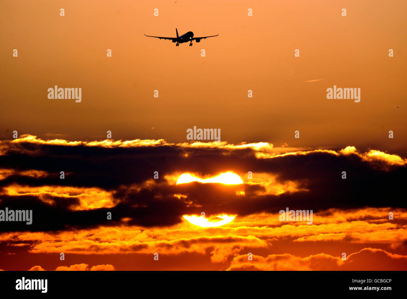 Un avion arrive à l'aéroport d'Heathrow lorsque le soleil se lève au-dessus de Londres. Banque D'Images