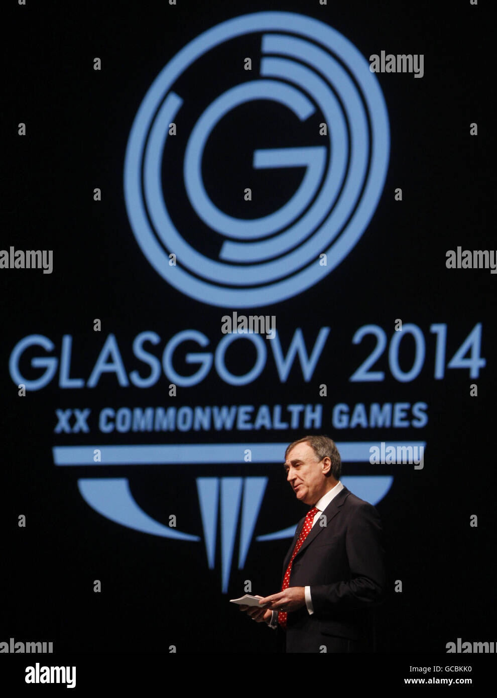 Le chef de la direction du comité organisateur de Glasgow 2014, John Scott, prononce un discours devant le nouveau logo des Jeux du Commonwealth de Glasgow 2014 lors de son lancement au Clyde Auditorium de Glasgow. Banque D'Images