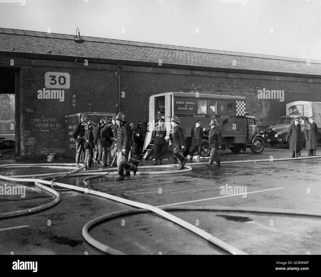 Pompiers le matin après un incendie désastreux d'entrepôt de whisky de Glasgow.Une explosion a fait exploser les murs du bâtiment, enterrant trois appareils d'incendie et tuant dix-neuf hommes, quatorze pompiers et 5 membres du corps de sauvetage de Glasgow.L'incident demeure le pire désastre des services d'incendie de Grande-Bretagne en temps de paix. Banque D'Images