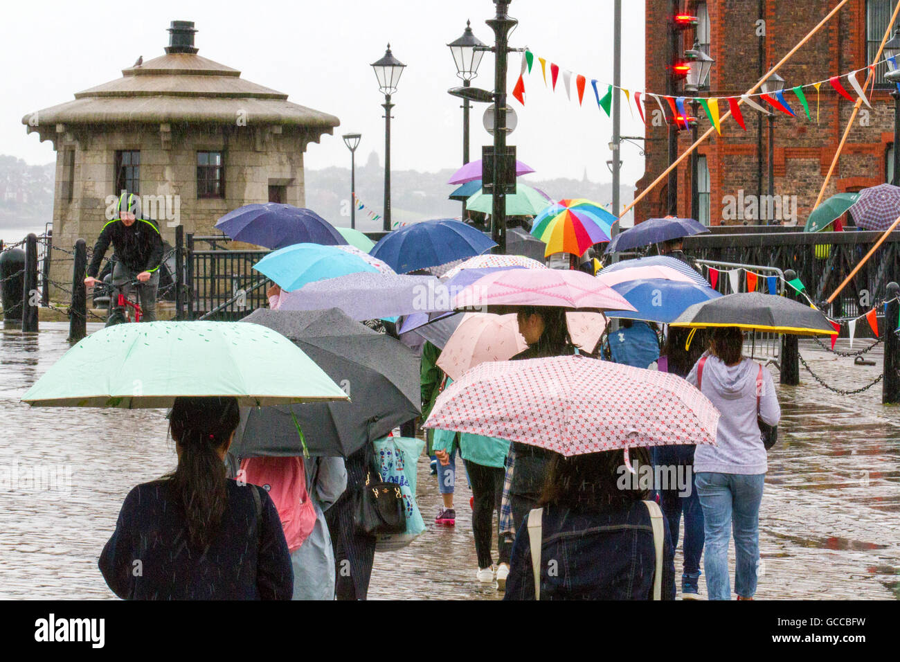 Les fortes précipitations, Liverpool. Météo France : 09-Juillet-2016. Averses de pluie torrentielles bienvenue des centaines d'étudiants étrangers qui visitent l'Albert Dock de Liverpool. Avec des températures inférieures à la moyenne saisonnière & cool de fortes averses sur la région, la météo ne montre aucun signe de laisser en place pour les visiteurs. Credit : Cernan Elias/Alamy Live News Banque D'Images