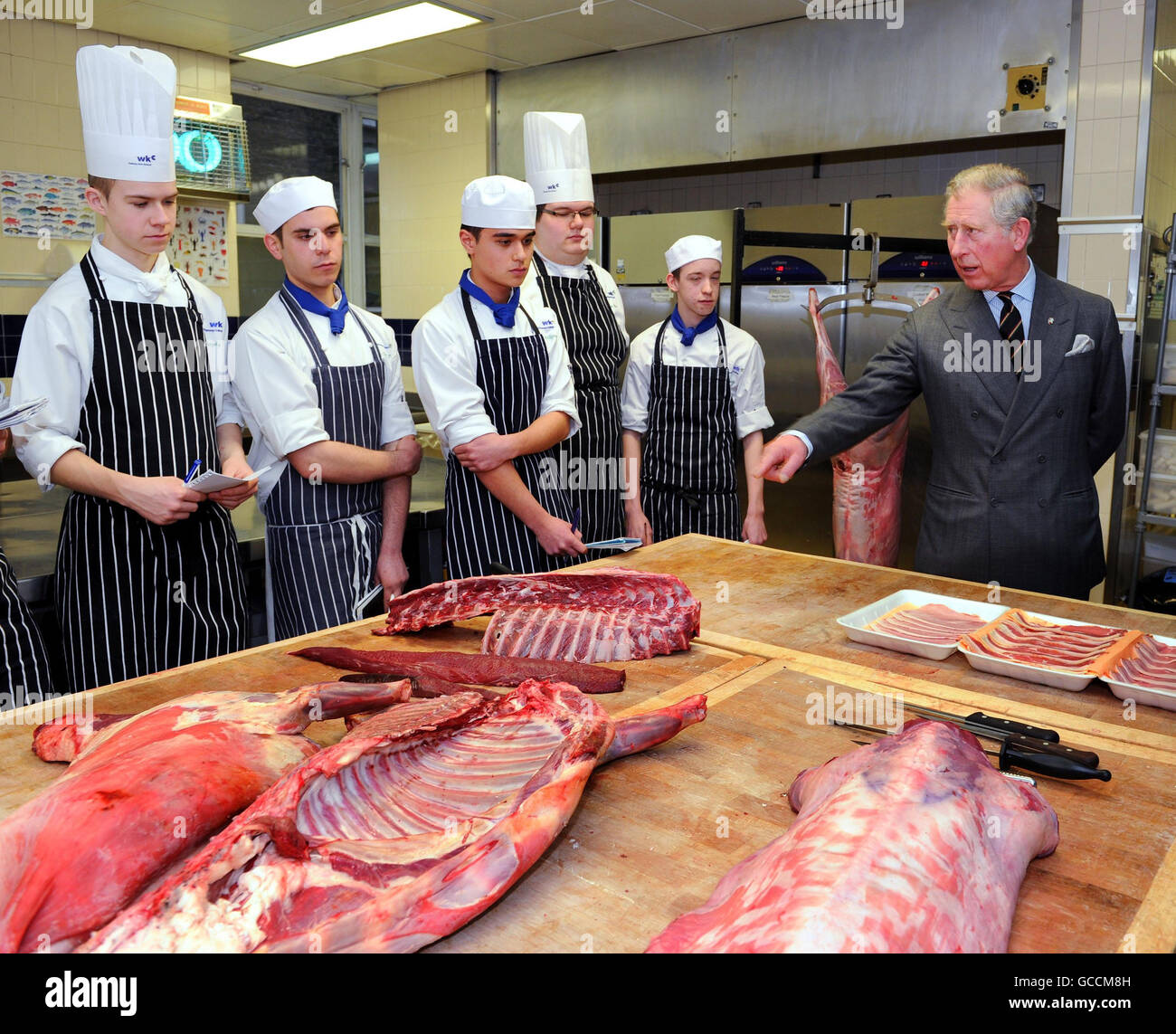 Le Prince de Galles s'entretient avec des étudiants en restauration, assistant à un cours de boucherie, lors d'une visite au Westminster Kingsway College, Londres. Banque D'Images