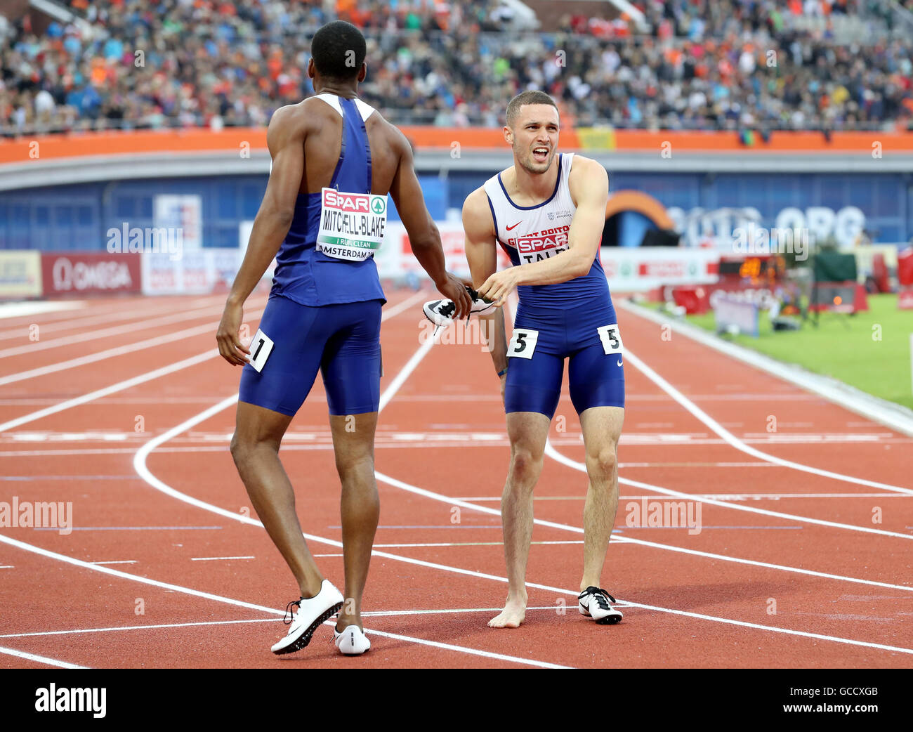 Great Britain's Danny Talbot (à droite) reçoit une crampe après avoir pris la quatrième place dans la finale du 200 mètres hommes au cours de la troisième journée du championnat d'athlétisme Européen 2016 au Stade Olympique d'Amsterdam. Banque D'Images