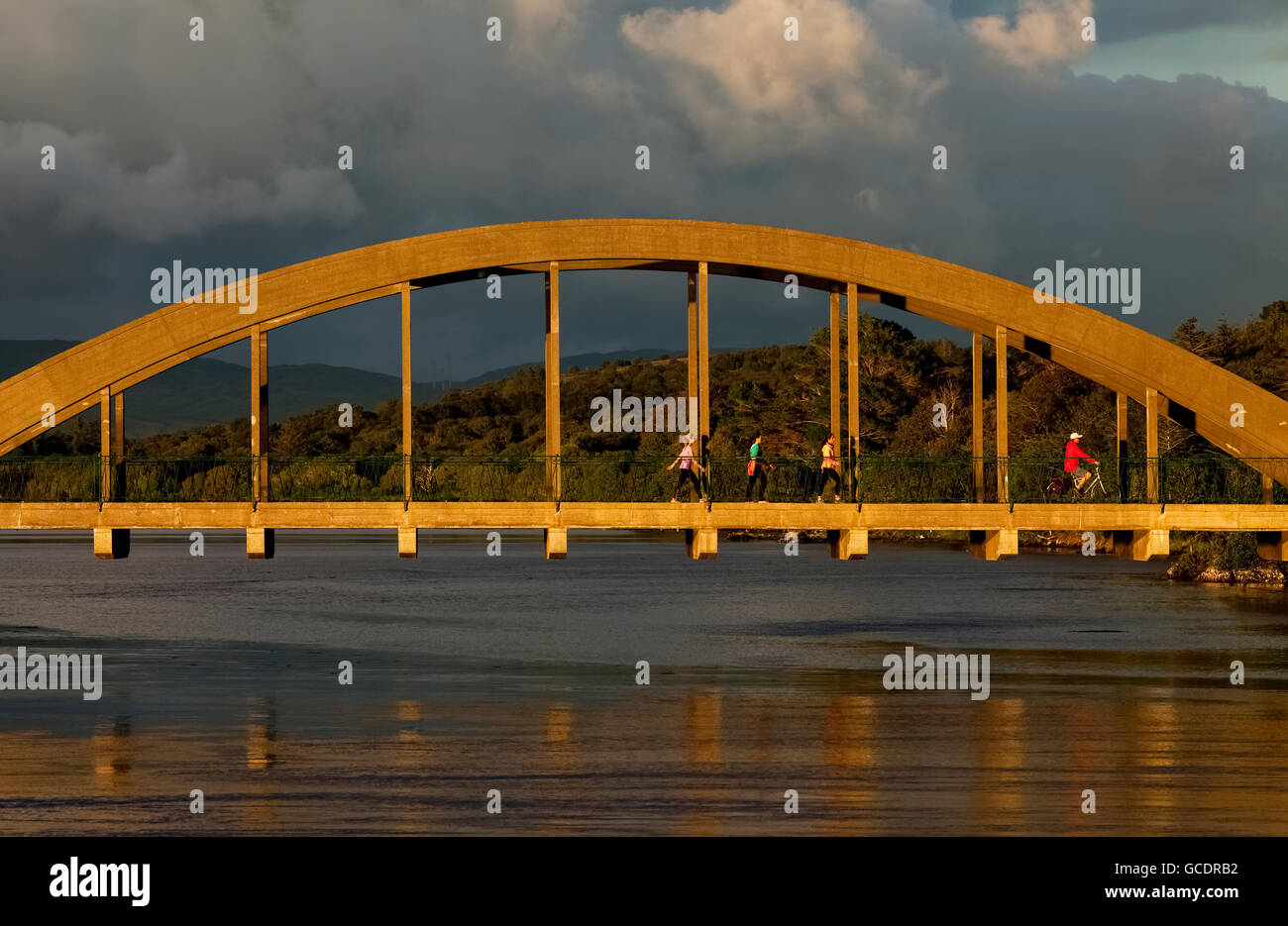 Piétons et un cycliste sur un pont sur la rivière ; Kenmare, comté de Kerry, Irlande Banque D'Images