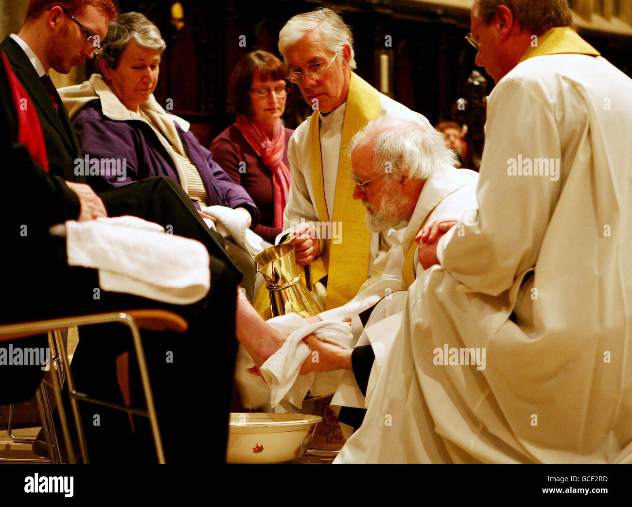 L'archevêque de Canterbury Dr Rowan Williams (à genoux au centre) exécute la cérémonie de lavage des pieds du jeudi Maundy, accompagnée du très révérend Robert Willis, (haut) doyen de la cathédrale de Canterbury, à Canterbury, dans le Kent. Banque D'Images