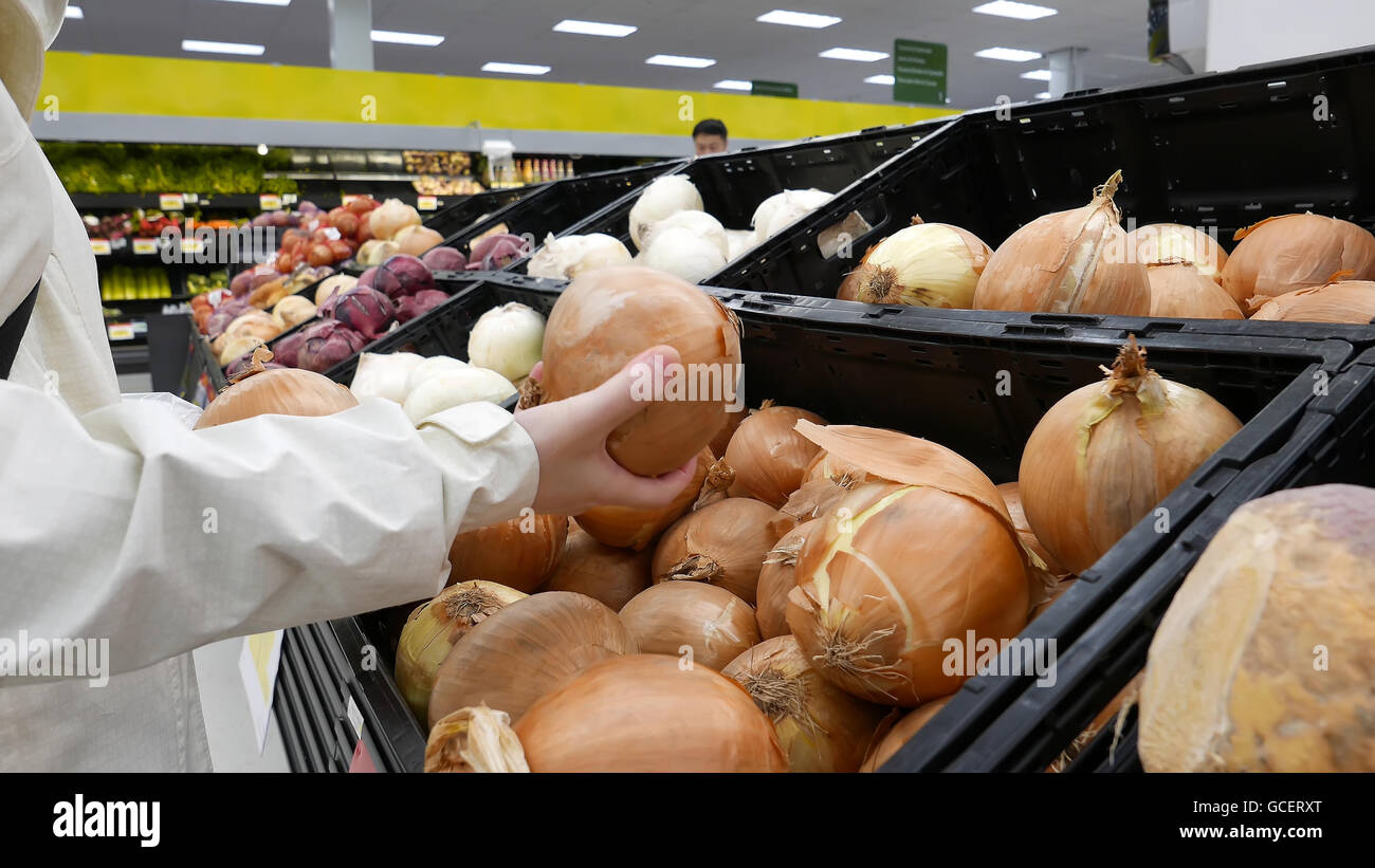 Woman picking oignon frais à l'intérieur magasin Walmart Banque D'Images