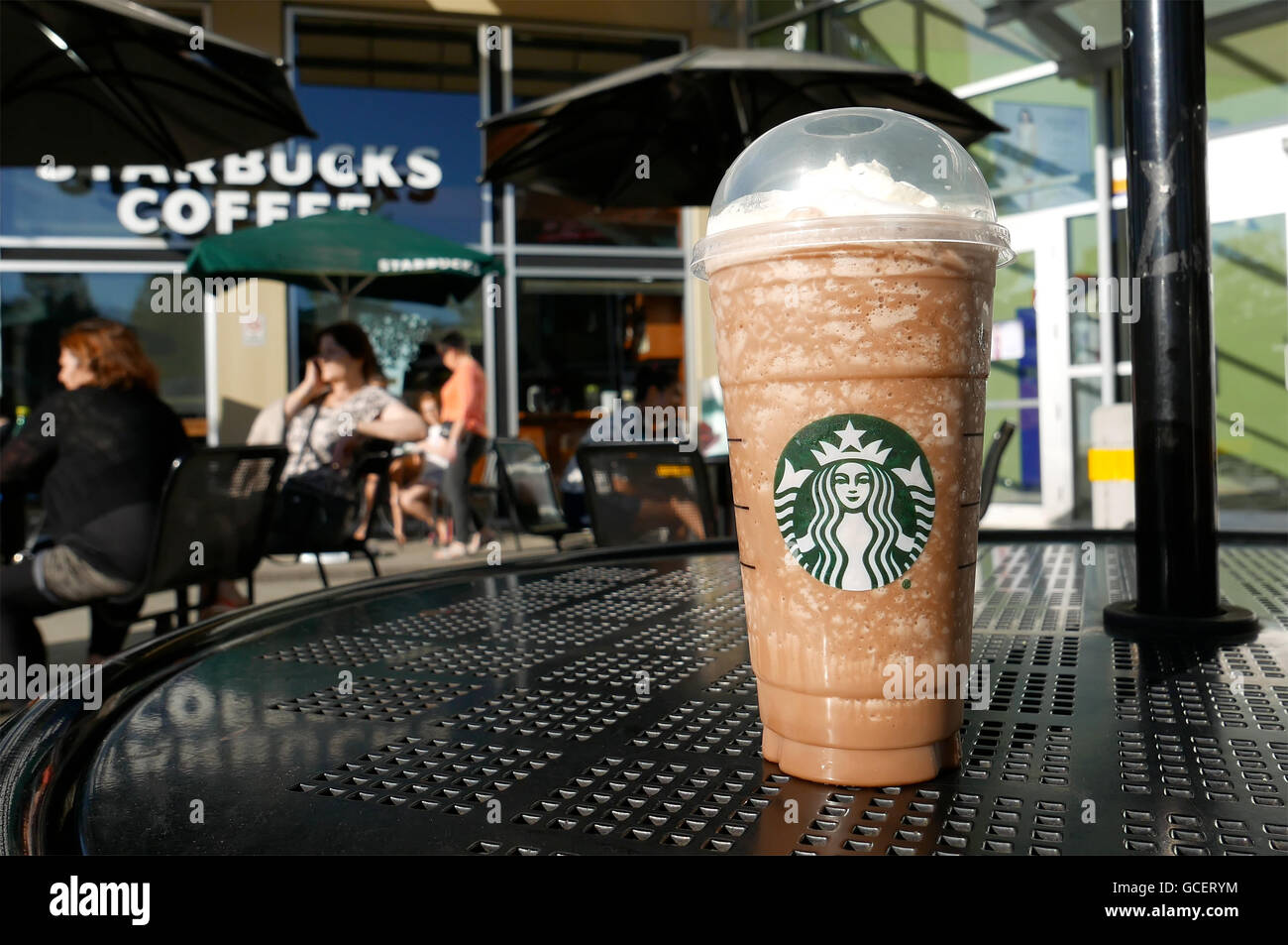 Un côté de gens boire du café Starbucks aux beaux jours, l'accent sur la glace moka frappuccino Banque D'Images