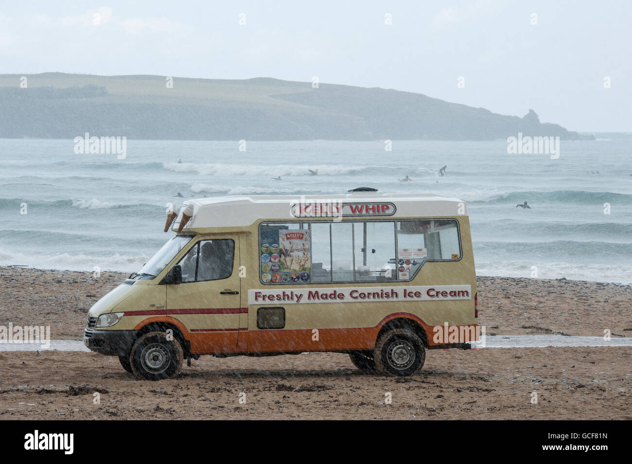 Une glace van sous la pluie battante sur une plage à Cornwall Banque D'Images