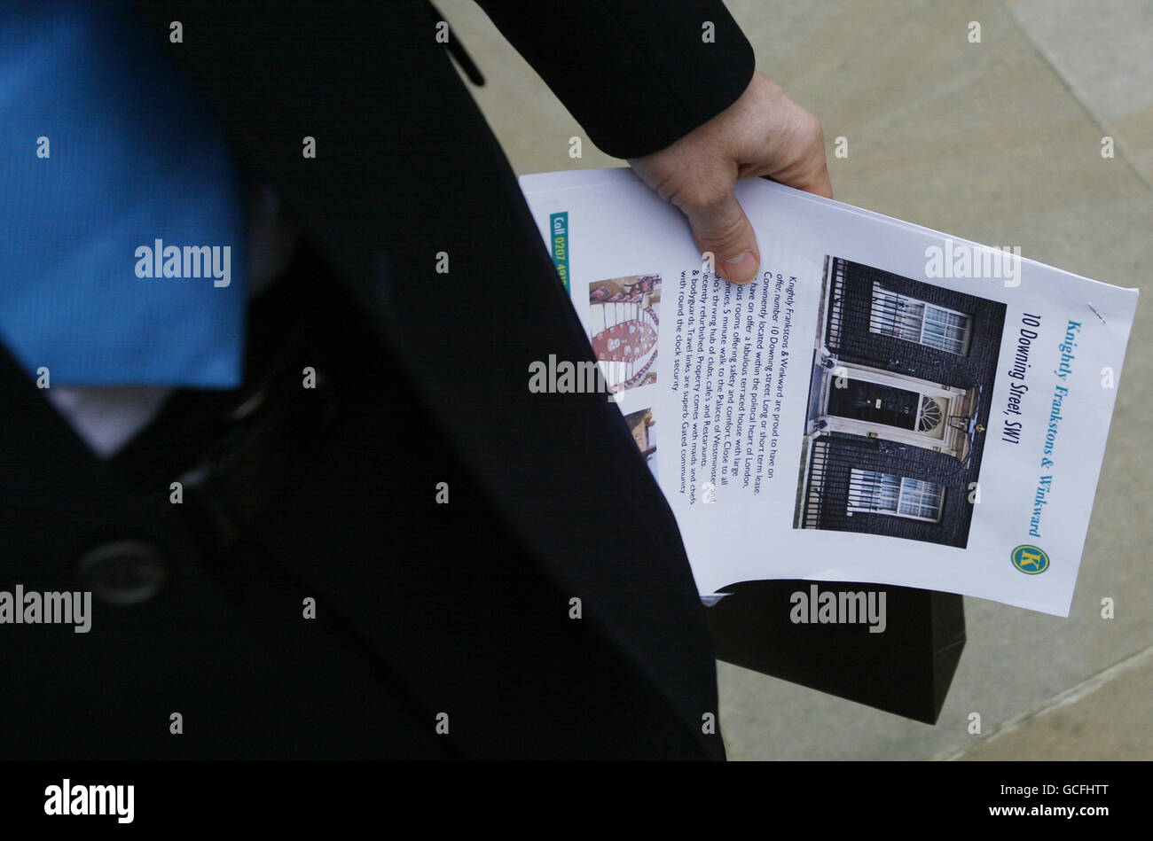 Un homme qui se pose comme une croix entre un agent immobilier et le chef du Parti conservateur David Cameron détient un prospectus d'agent immobilier d'un spoof du 10 Downing Street, lors d'une cascade politique à l'extérieur de Downing Street à Westminster, dans le centre de Londres, à l'approche du jour du scrutin des élections générales. Banque D'Images