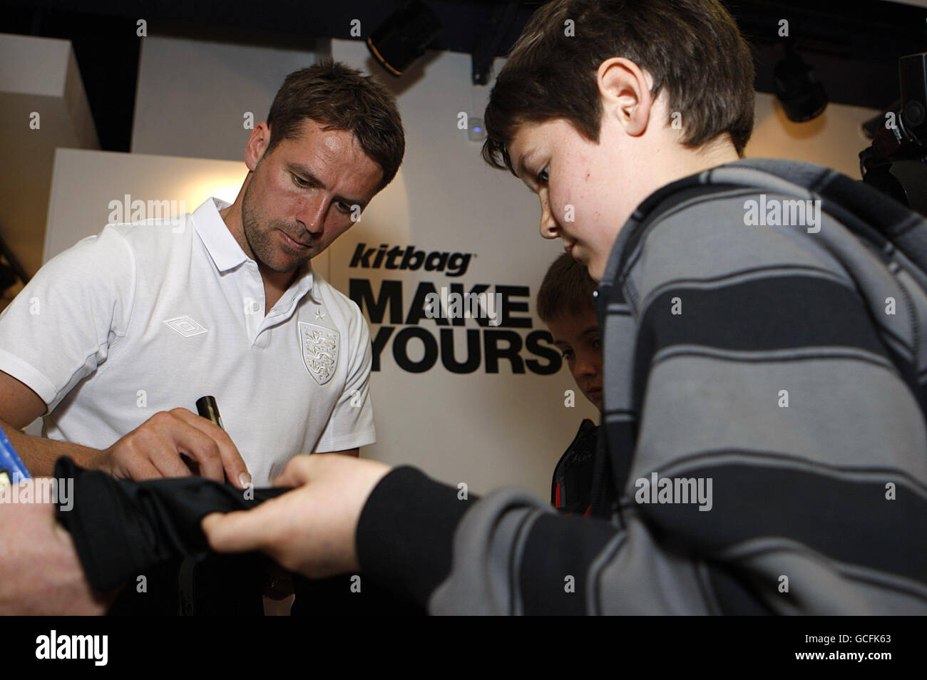 Michael Owen signe une chemise pour les enfants du comté de Louth en Irlande pendant le photocall au magasin Kitbag, Manchester. Banque D'Images