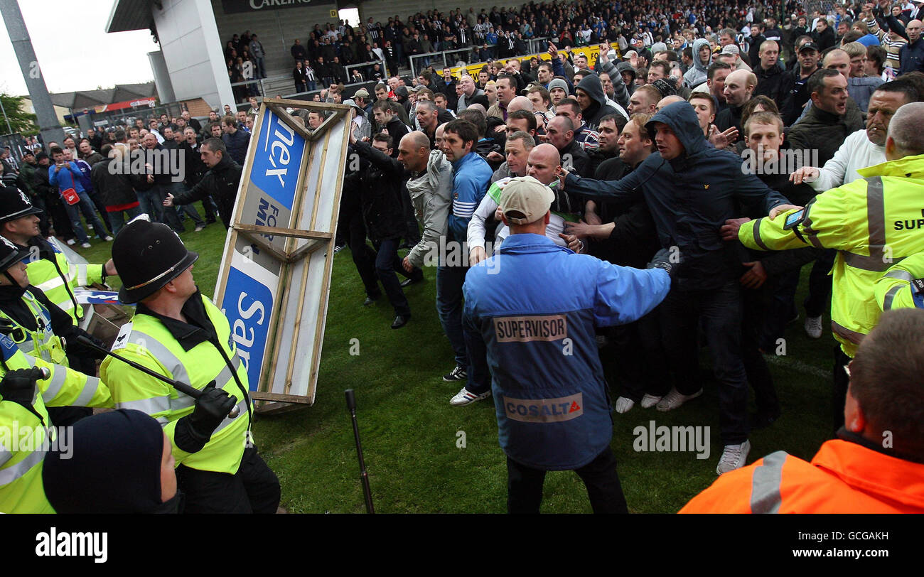 Les fans lancent un panneau publicitaire à la police alors que la violence éclate à la fin du match pendant le match de la Coca Cola League Two au stade Pirelli, Burton. Banque D'Images