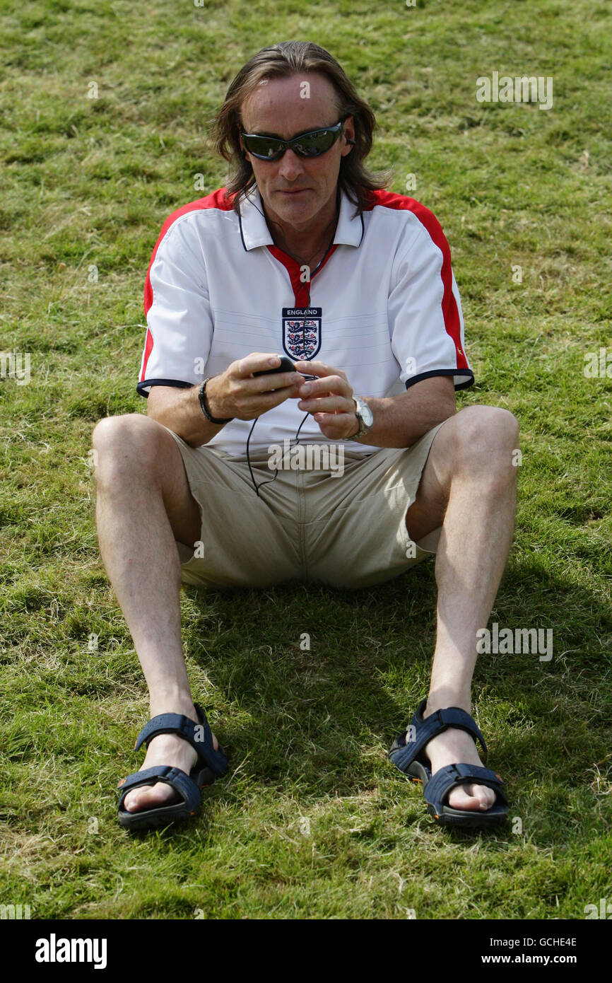Dave Fisher, fan de football d'Angleterre, de Hitchin, écoute le match Angleterre contre Slovénie à sa radio, sur Murray Mount pendant le troisième jour des championnats de Wimbledon 2010 au All England Lawn tennis Club, Wimbledon. Banque D'Images