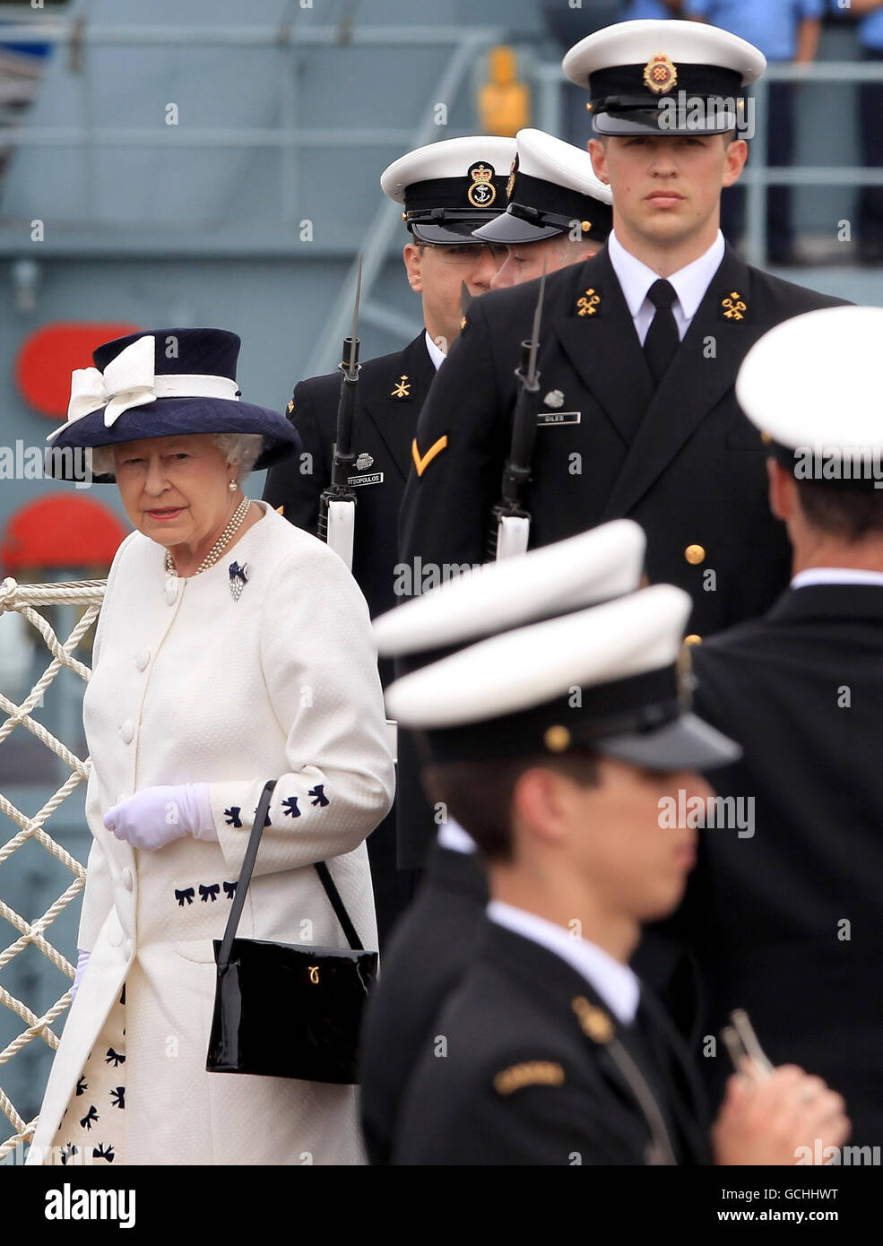 La reine Elizabeth II de Grande-Bretagne arrive à bord du NCSM St John's après une revue de la Marine pour souligner le 100e anniversaire de la Marine canadienne, dans les eaux au large de Halifax, en Nouvelle-Écosse, au Canada. Banque D'Images