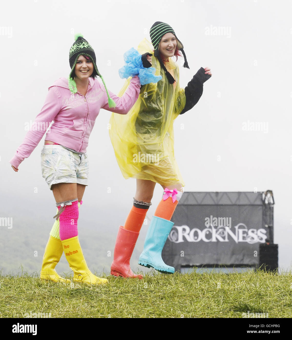 (De gauche à droite) les fêtards Leighanne Gillespie et Sarah Casey dansent sous la pluie pendant le festival de musique RockNess près d'Inverness, en Écosse. Banque D'Images