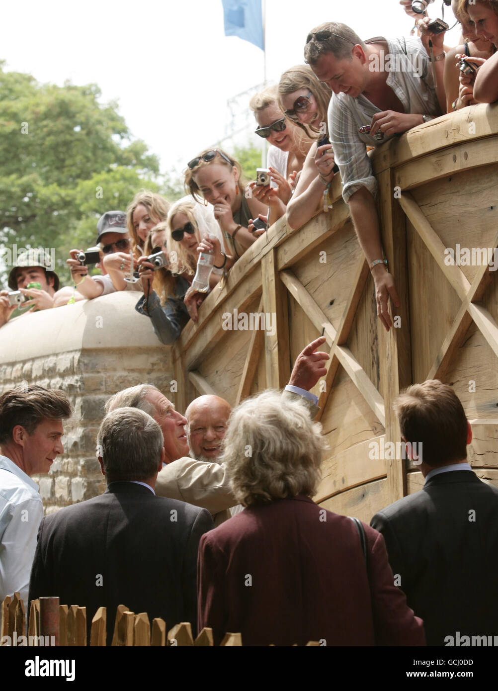 Le Prince de Galles (devant, troisième à gauche) rencontre des fêtards sur le pont Bella's Bridge lorsqu'il visite le festival Glastonbury 2010 pour marquer le 40e anniversaire de l'événement, à la ferme digne, Pilton dans le Somerset. Banque D'Images