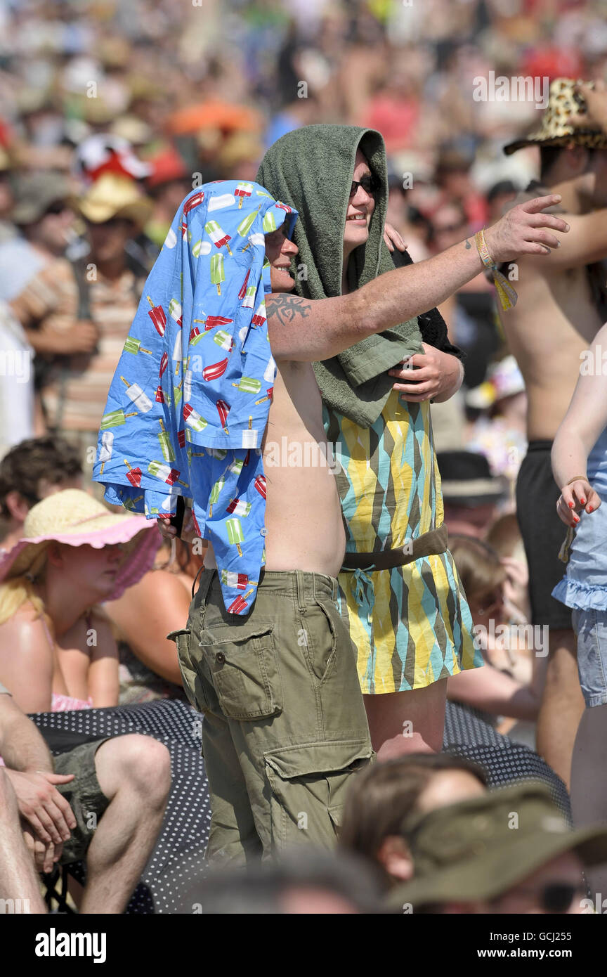 Les fêtards utilisent tout ce qu'ils peuvent pour chercher l'ombre du soleil tandis que les températures montent pendant le festival Glastonbury 2010 à la ferme digne de Pilton, Somerset. Banque D'Images