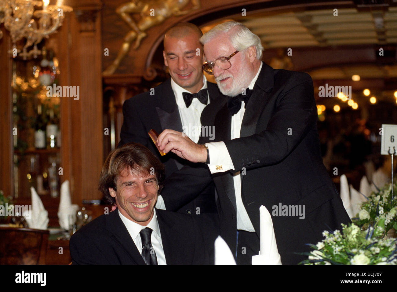 LE JOUEUR DE CHELSEA GIANFRANCO ZOLA REÇOIT L'ATTENTION DE CHARMAN KEN BATES, TANDIS QUE LE JOUEUR MANAGER GIANLUCA VIALLI REGARDE LE LANCEMENT DU NOUVEAU RESTAURANT VÉNITIEN DU CLUB DE FOOTBALL DE CHELSEA, CANALTTOS, À LEUR STADE STAMFORD BRIDGE À LONDRES. Banque D'Images