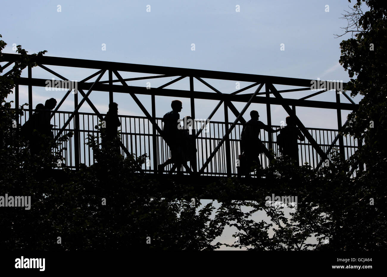 Les amateurs de tennis traversent le pont pour faire la queue pour obtenir des billets pendant le cinquième jour des Championnats de Wimbledon 2010 au All England Lawn tennis Club, Wimbledon. Banque D'Images