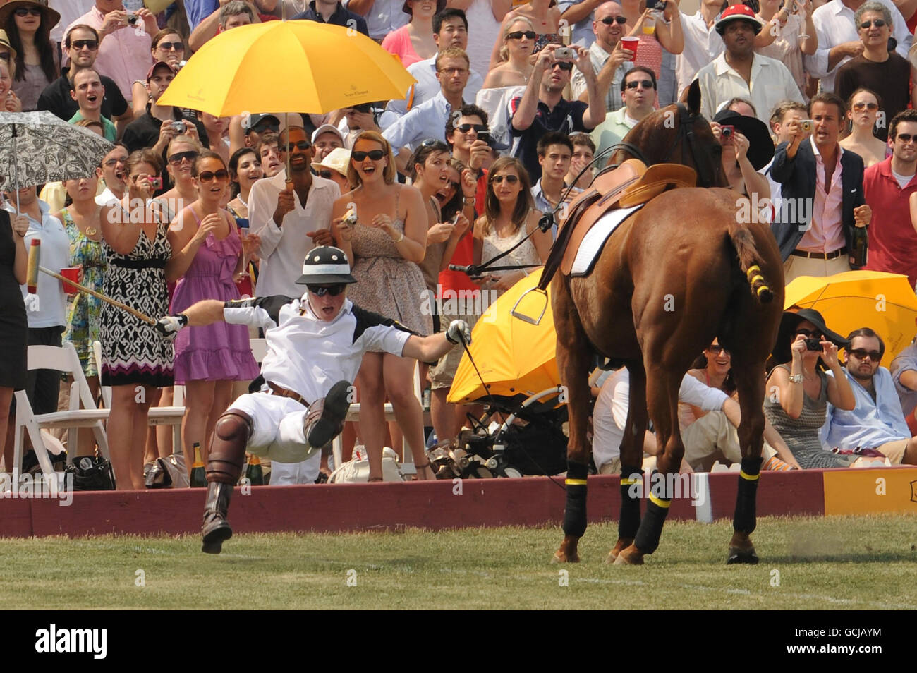 Le prince Harry tombe de son cheval pendant la 3e édition annuelle du Polo Classic veuve Clicquot sur Governors Island à New York. Banque D'Images