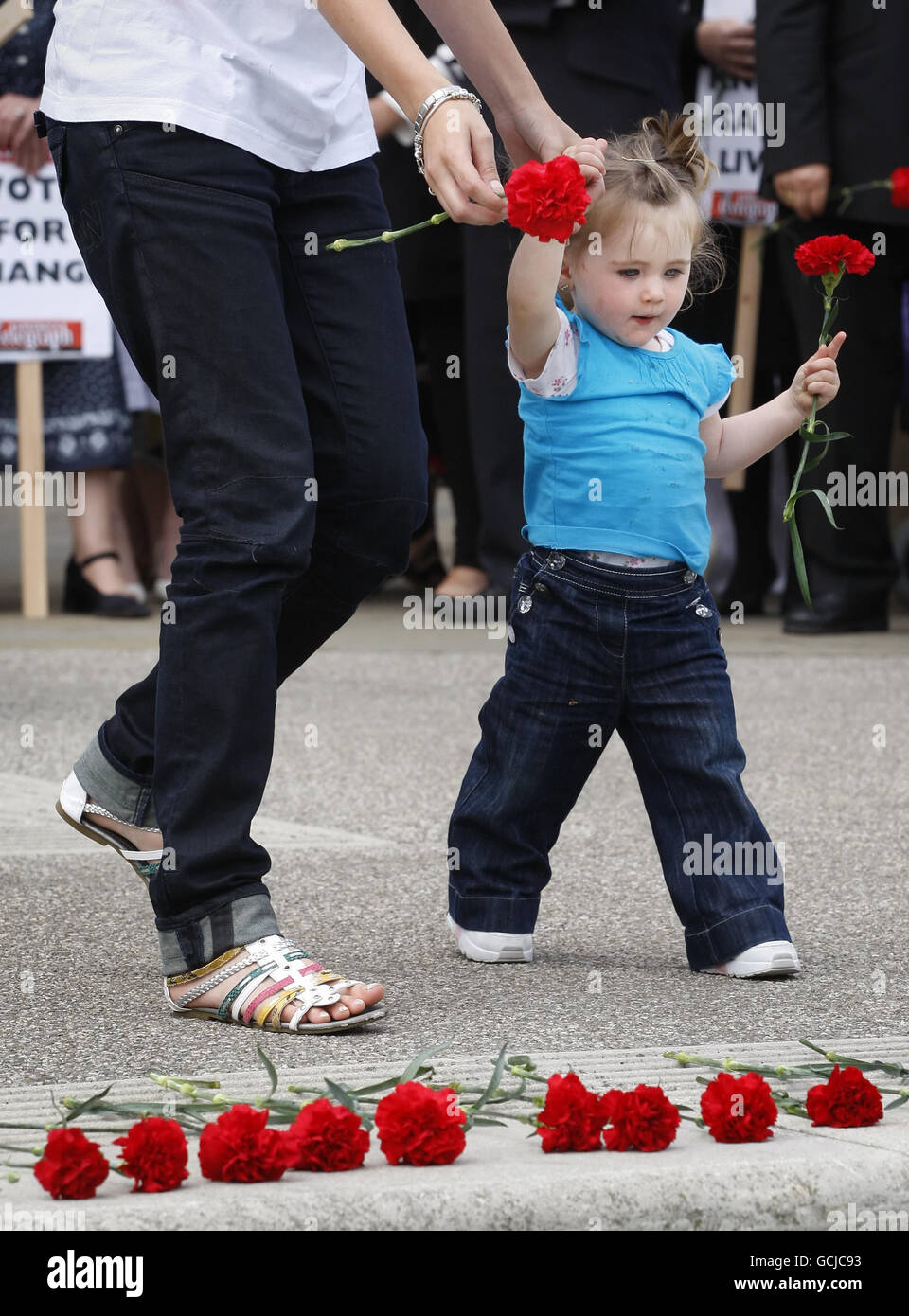 Un jeune enfant dépose une caricature rouge devant le Parlement écossais lors d’une manifestation organisée par des militants demandant des peines de prison obligatoires pour crimes commis par des couteaux. Banque D'Images
