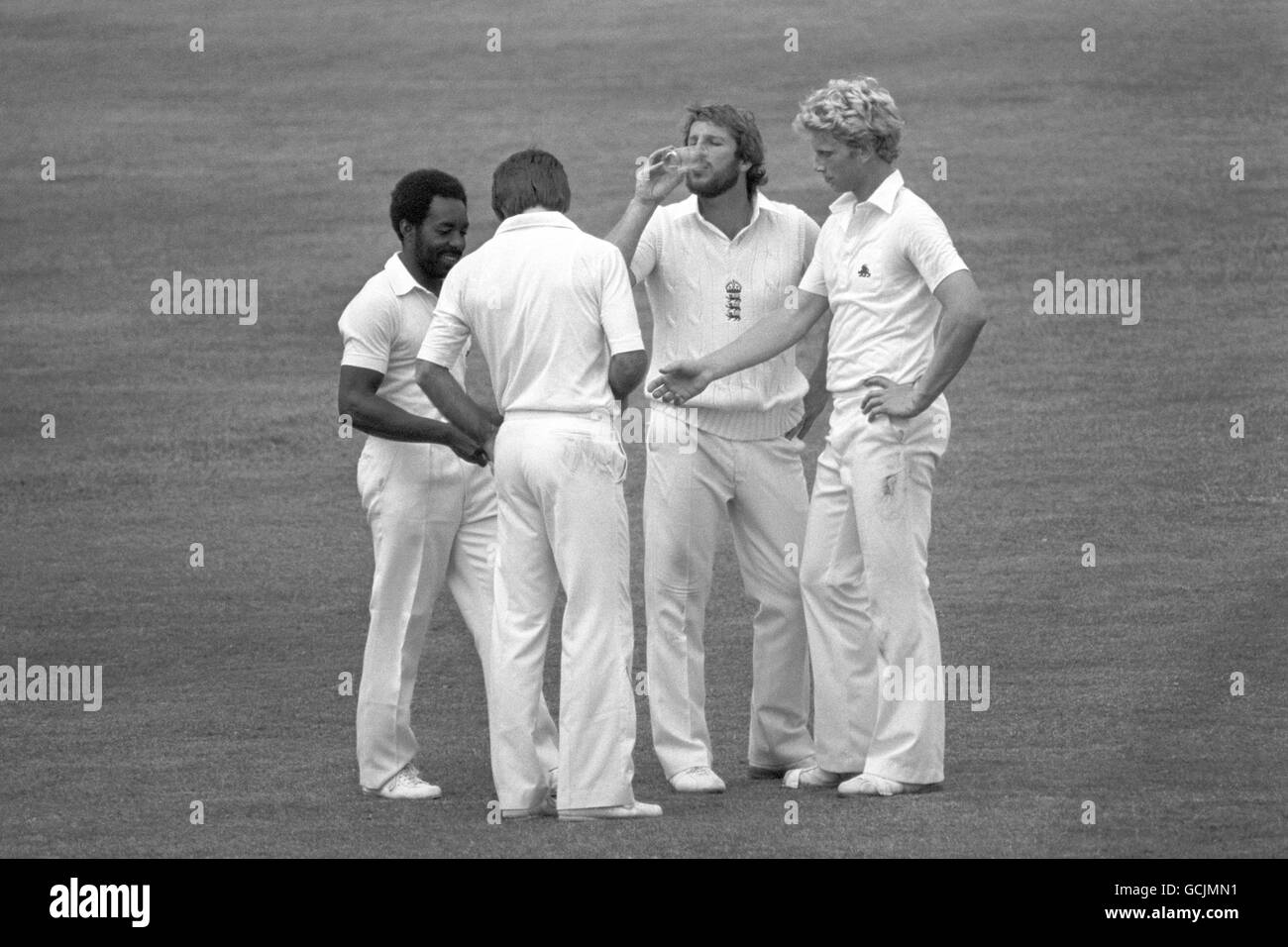 Le capitaine d'Angleterre Ian Botham a un verre d'eau pendant une pause.On trouve également sur la photo le 12e homme Roland Butcher (l) Peter Willey et Graham Dilley (r) Banque D'Images