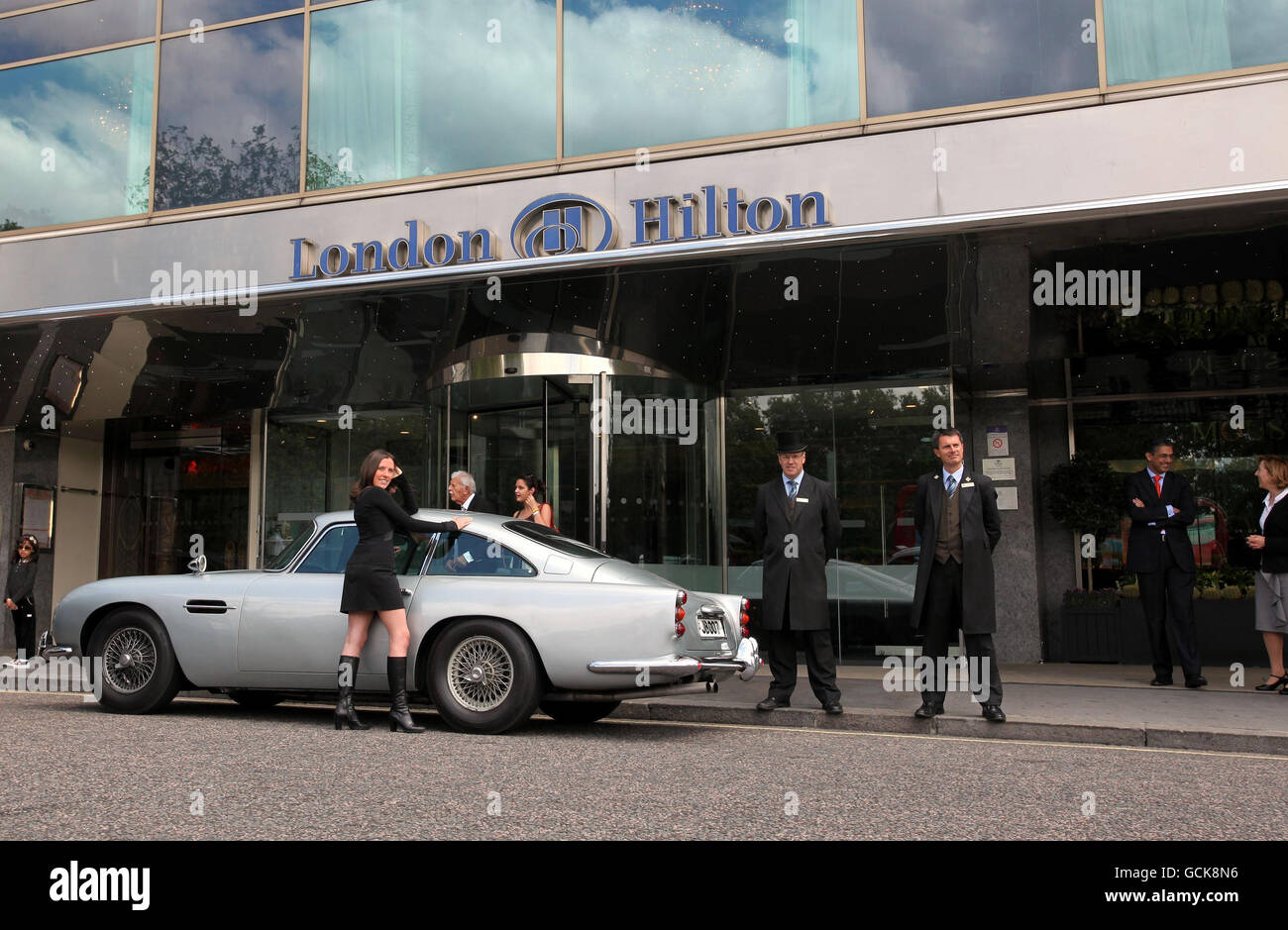 Martina Rossi, employée de l'hôtel, se tient par Aston Martin DB5 de James Bond, conduit par Sean Connery à Goldfinger et Thunderball lors d'une séance photo devant le London Hilton, Park Lane, avant sa vente aux enchères par RM Auctions le 27 octobre, la même voiture a visité l'hôtel pour la dernière fois en 1969. Banque D'Images