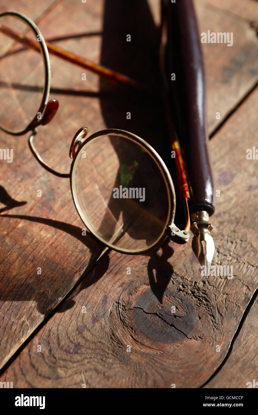 Old vintage spectacles près de stylo sur fond en bois Banque D'Images