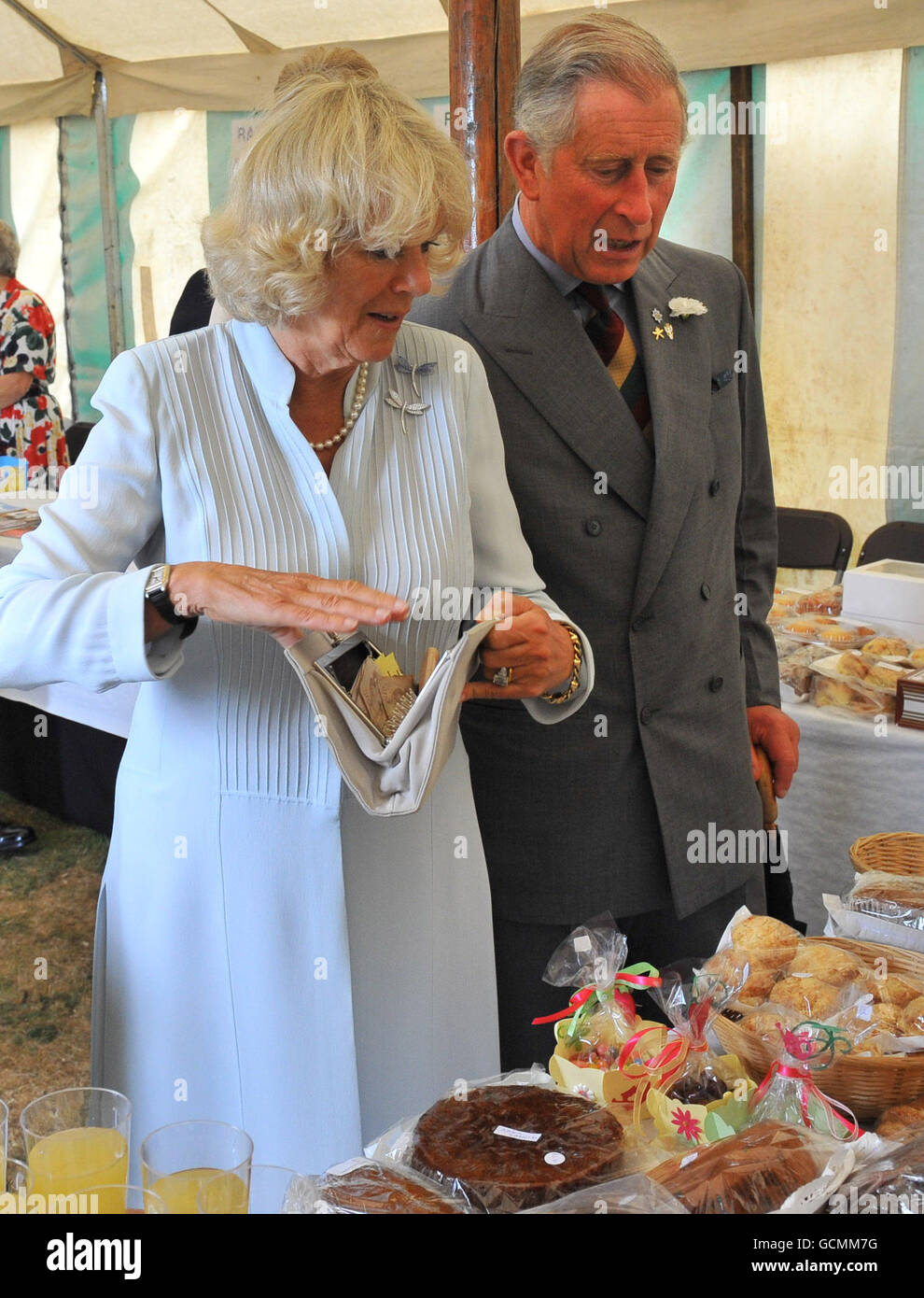 Le Prince de Galles se penche sur le fait que la duchesse de Cornwall achète un gâteau au gingembre au spectacle de fleurs de Sandringham, qui a eu lieu sur le domaine royal de Norfolk. Banque D'Images