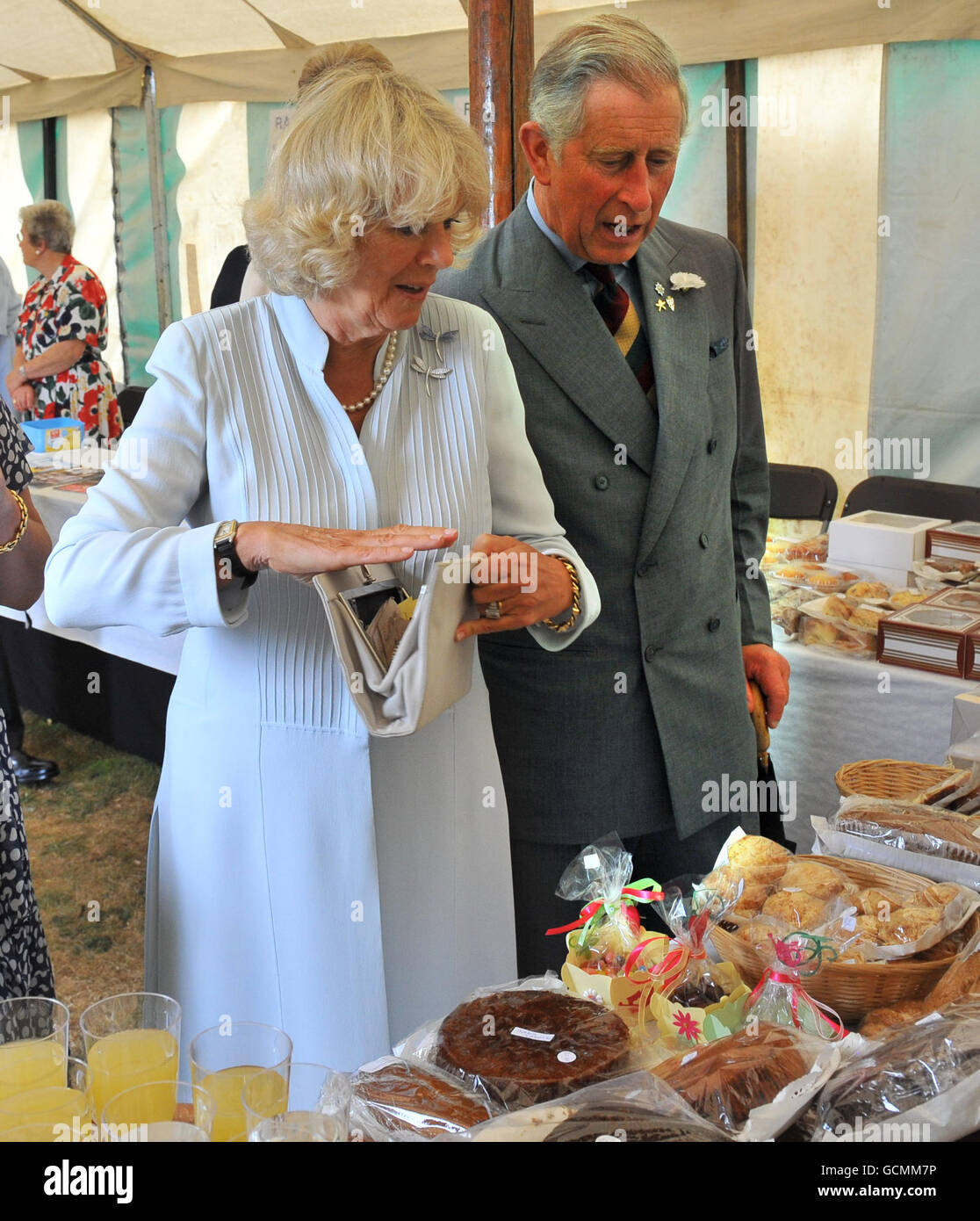 Le Prince de Galles se penche sur le fait que la duchesse de Cornwall achète un gâteau au gingembre au spectacle de fleurs de Sandringham, qui a eu lieu sur le domaine royal de Norfolk. Banque D'Images