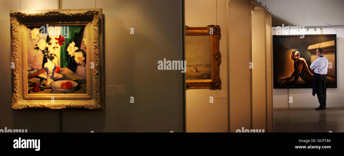 Norman Wyllie, employé de Sotheby, examine une œuvre des artistes Peter Howson, intitulée « Phoenix » et une œuvre des artistes Samuel John Peploe, intitulée « la vie de Roses dans un vase bleu et blanc », estimée à 250,000-350,000, à gauche du cadre, Lors d'un photocall à Mansfield Traquair à Édimbourg, à l'approche de Sotheby's Scottish sale. Banque D'Images