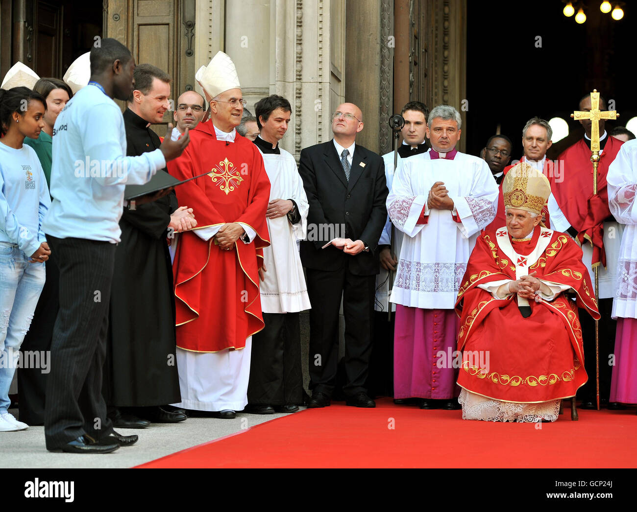 Paschal Uche (deuxième gauche) accueille le Pape Benoît XVI, au nom des jeunes Britanniques, alors que le Pape s'assoit sur les marches de la cathédrale de Westminster, dans le centre de Londres, après avoir célébré la Messe. Banque D'Images