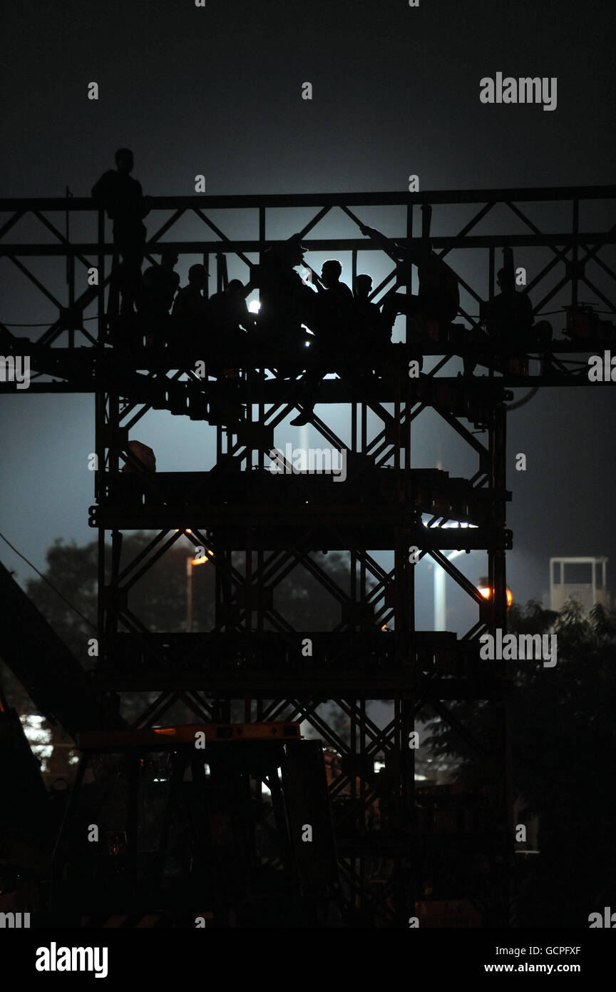 L'armée poursuit les travaux de construction tout au long de la nuit sur un pont de remplacement à l'extérieur du stade Nehru, le stade principal des Jeux du Commonwealth de 2010 à New Delhi, en Inde. Banque D'Images