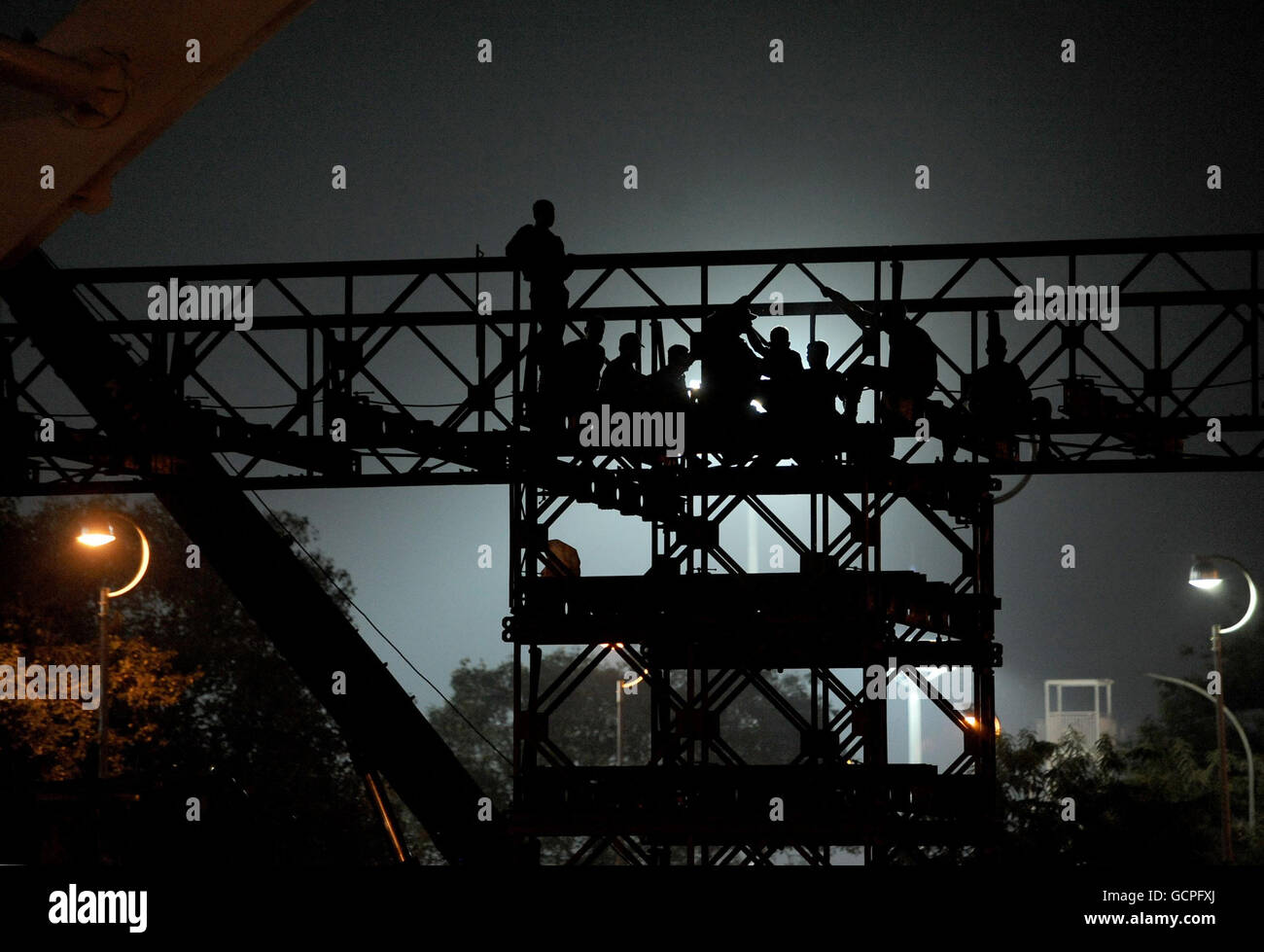 L'armée poursuit les travaux de construction tout au long de la nuit sur un pont de remplacement à l'extérieur du stade Nehru, le stade principal des Jeux du Commonwealth de 2010 à New Delhi, en Inde. Banque D'Images