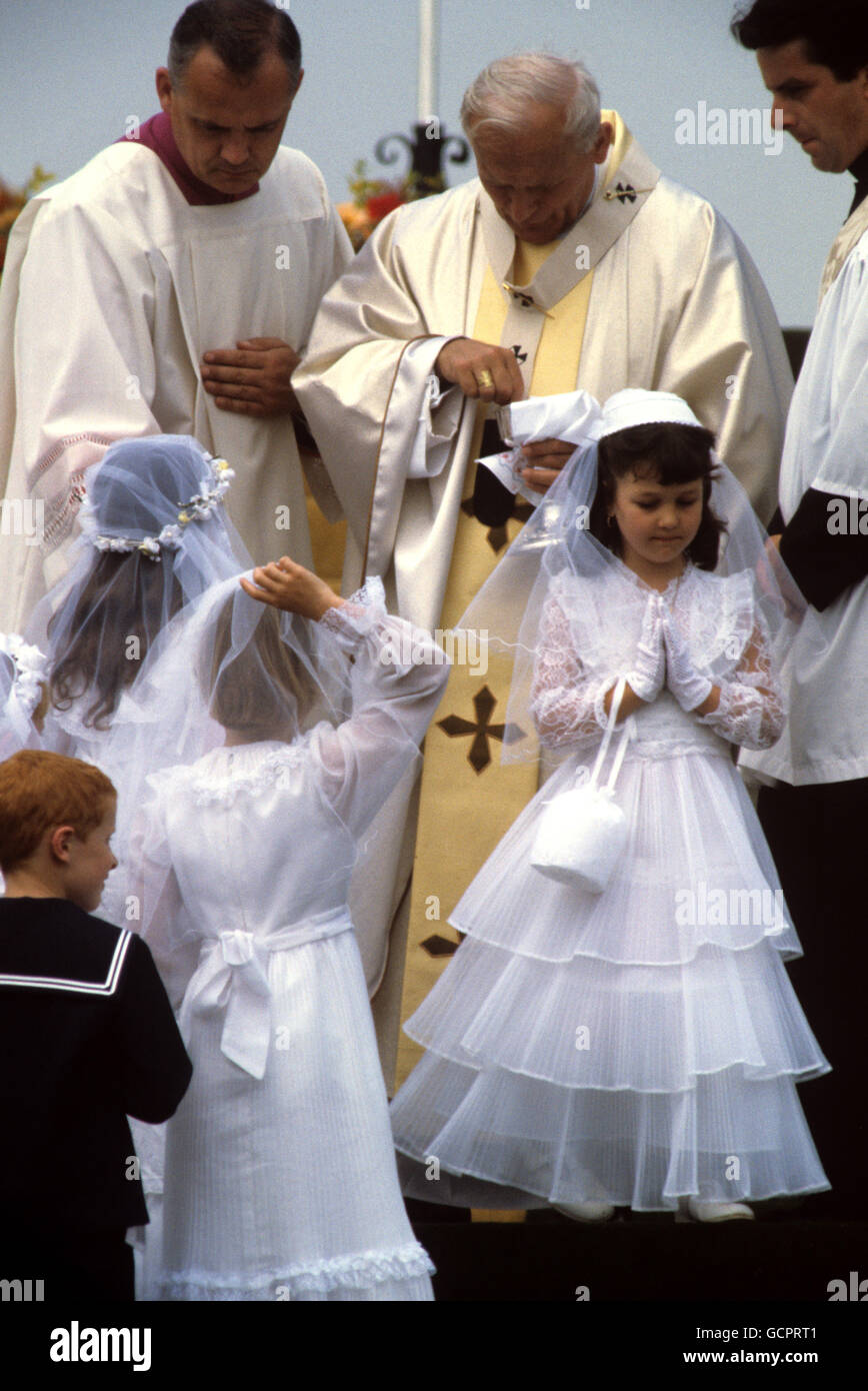 Le pape Jean-Paul II exécute la cérémonie de confirmation pour les enfants pendant la messe en plein air, à Pontcann Fields, Cardiff Banque D'Images