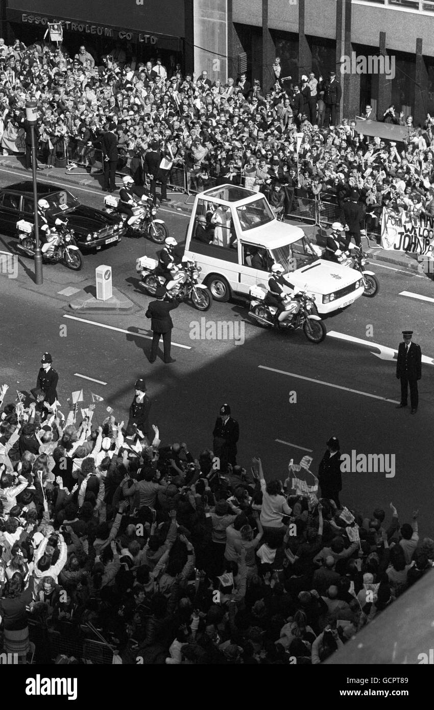 Les foules applaudissent et agitent pour accueillir le pape Jean-Paul II, alors qu'il descend la rue Victoria dans son « Popemobile » sur la route de la cathédrale de Westminster. Banque D'Images